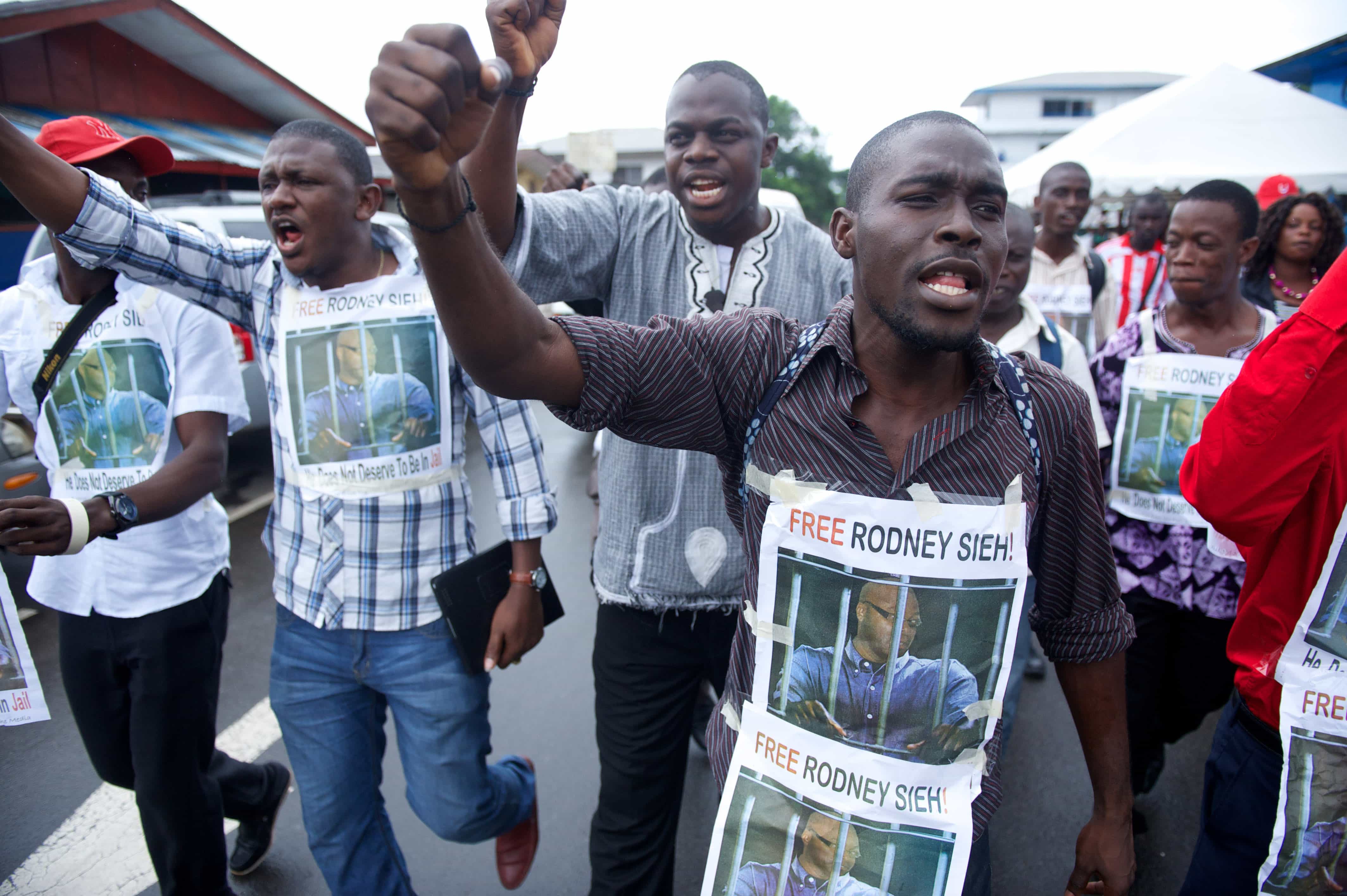 Members of the press protest against the ongoing imprisonment of Rodney Sieh, at a rally outside the Press Union of Liberia, in Monrovia, 23 September 2013. , AP Photo/Mark Darrough