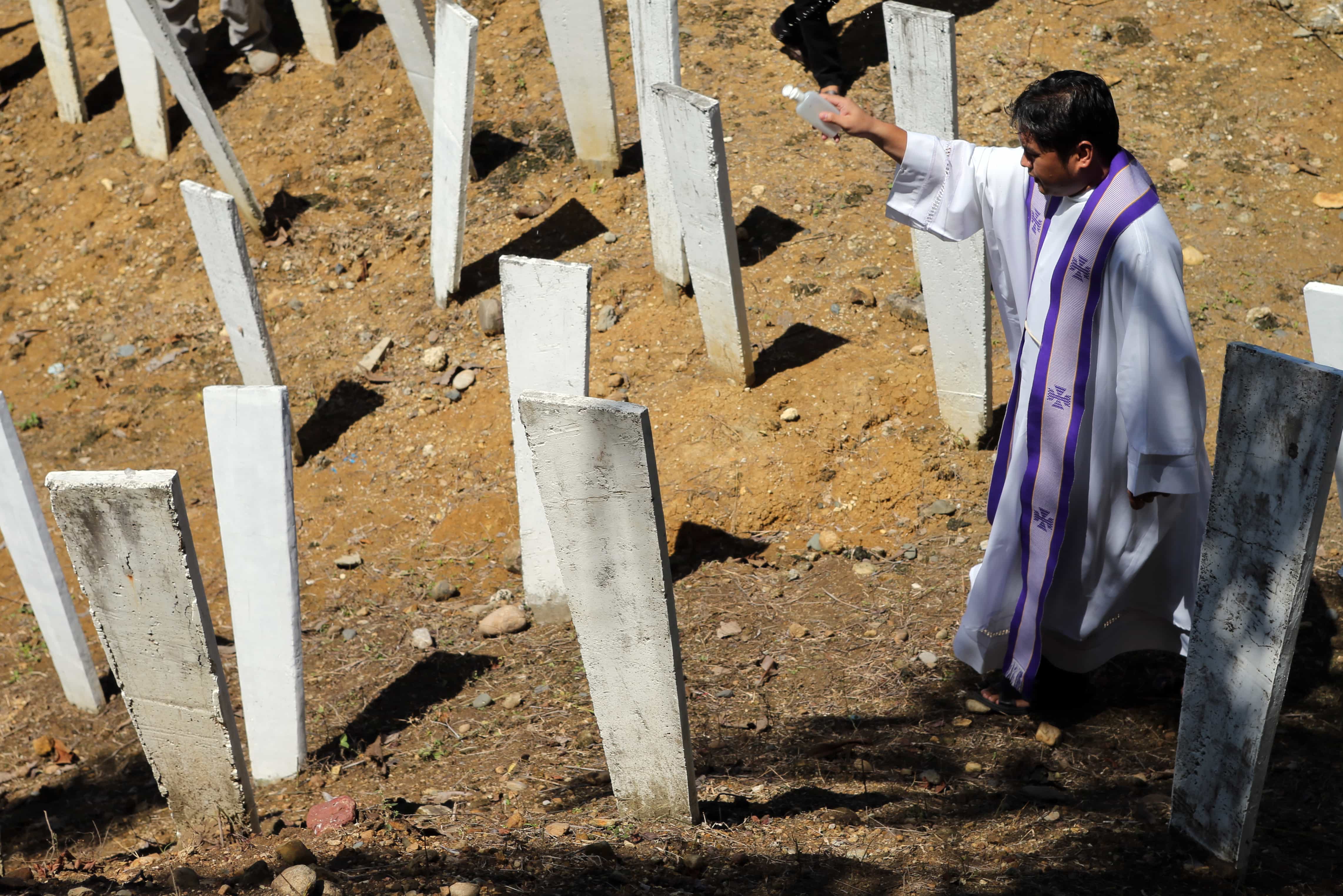 A Roman Catholic priest blesses the site where 58 people, 32 of them journalists, were killed in the southern town of Ampatuan, Maguindanao, Philippines, 21 November, 2014, Jeoffrey Maitem/Getty Images