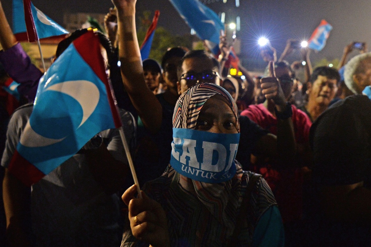 A supporter waves a party flag as federal opposition leader Anwar Ibrahim addresses a rally in Kuala Lumpur, Malaysia, 16 May 2018, ROSLAN RAHMAN/AFP/Getty Images