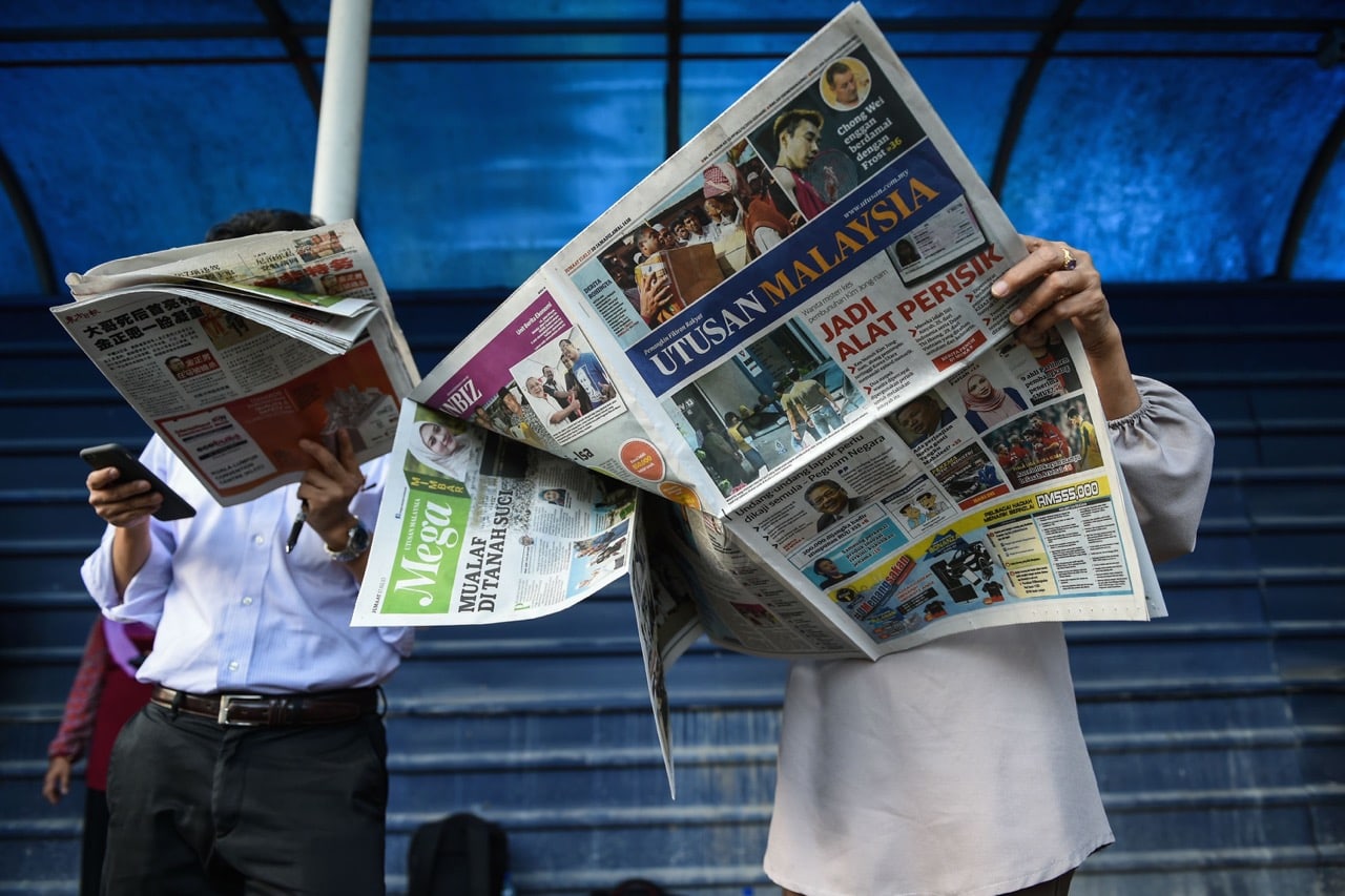 Journalists read newspapers with reports about the killing of a North Korean man outside the Kuala Lumpur Hospital, in Kuala Lumpur, Malaysia, 17 February 2017, MOHD RASFAN/AFP/Getty Images