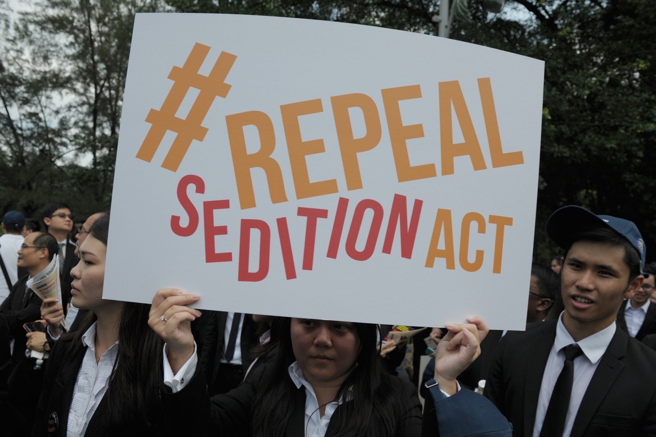A Malaysian lawyer holds a placard outside the Parliament house during a rally to repeal the Sedition Act, in Kuala Lumpur, 16 October 2014, MOHD RASFAN/AFP/Getty Images