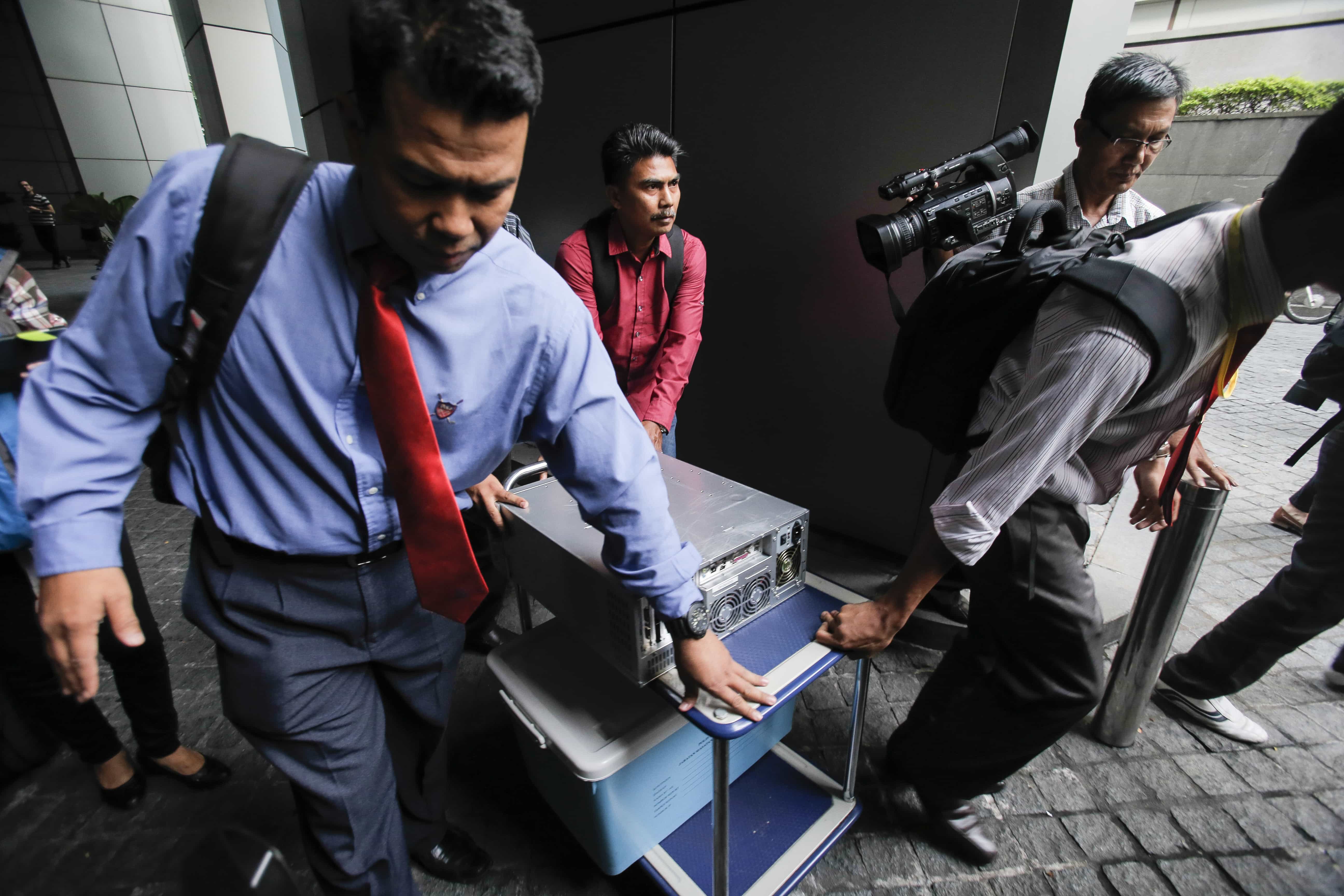 Malaysian plainclothes police carry a computer from the 1MDB office after a raid in Kuala Lumpur, 8 July 2015. Six bank accounts were frozen as part of an investigation into allegations that funds were transferred from a state investment fund to the personal accounts of PM Najib, AP Photo/Joshua Paul