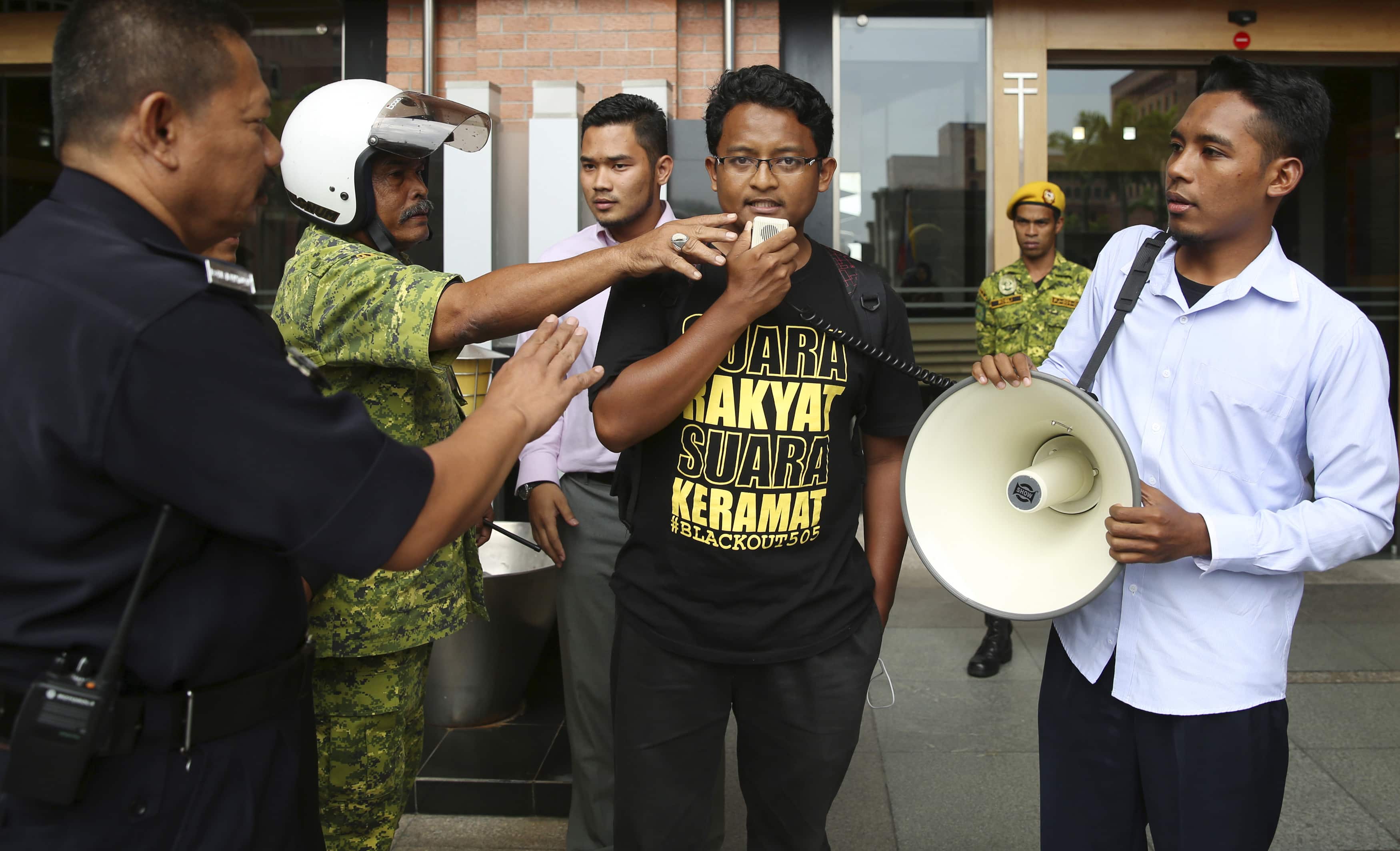 Authorities try to take a microphone from university student leader Fahmi Moktar as he calls for the repeal of the Sedition Act, 5 September 2014, REUTERS/Olivia Harris