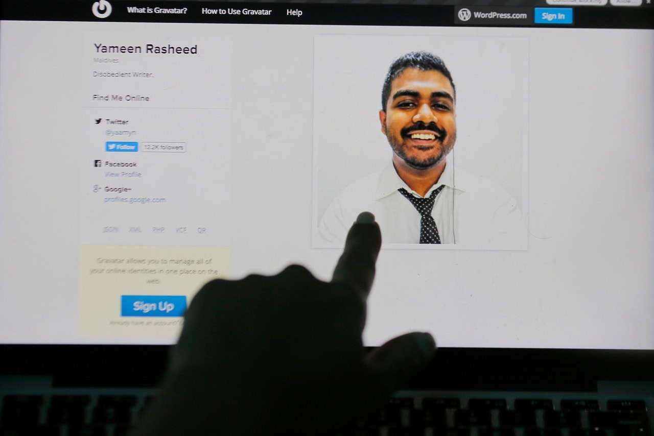 A Sri Lankan woman points to a portrait of Maldivian blogger Yameen Rasheed on his blog "The Daily Panic" in Colombo, Sri Lanka, 23 April 2017, AP Photo/Eranga Jayawardena