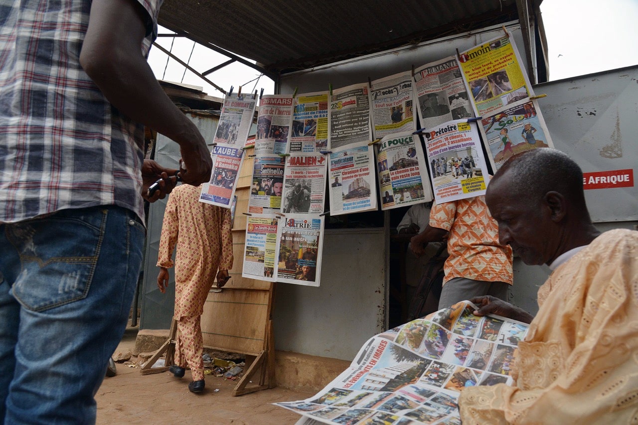 A man reads a newspaper next to a newsstand in Bamako, Mali, 23 November 2015, ISSOUF SANOGO/AFP/Getty Images