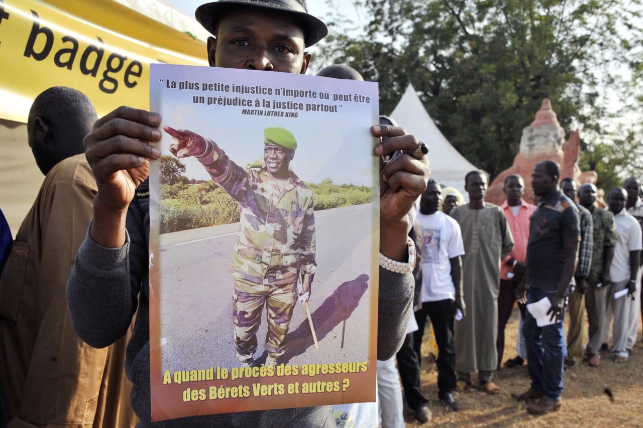 A protester holds a placard reading 'Injustice anywhere is a threat to justice everywhere' outside a courthouse in Sikasso, Mali, 30 November 2016,  -/AFP/Getty Images