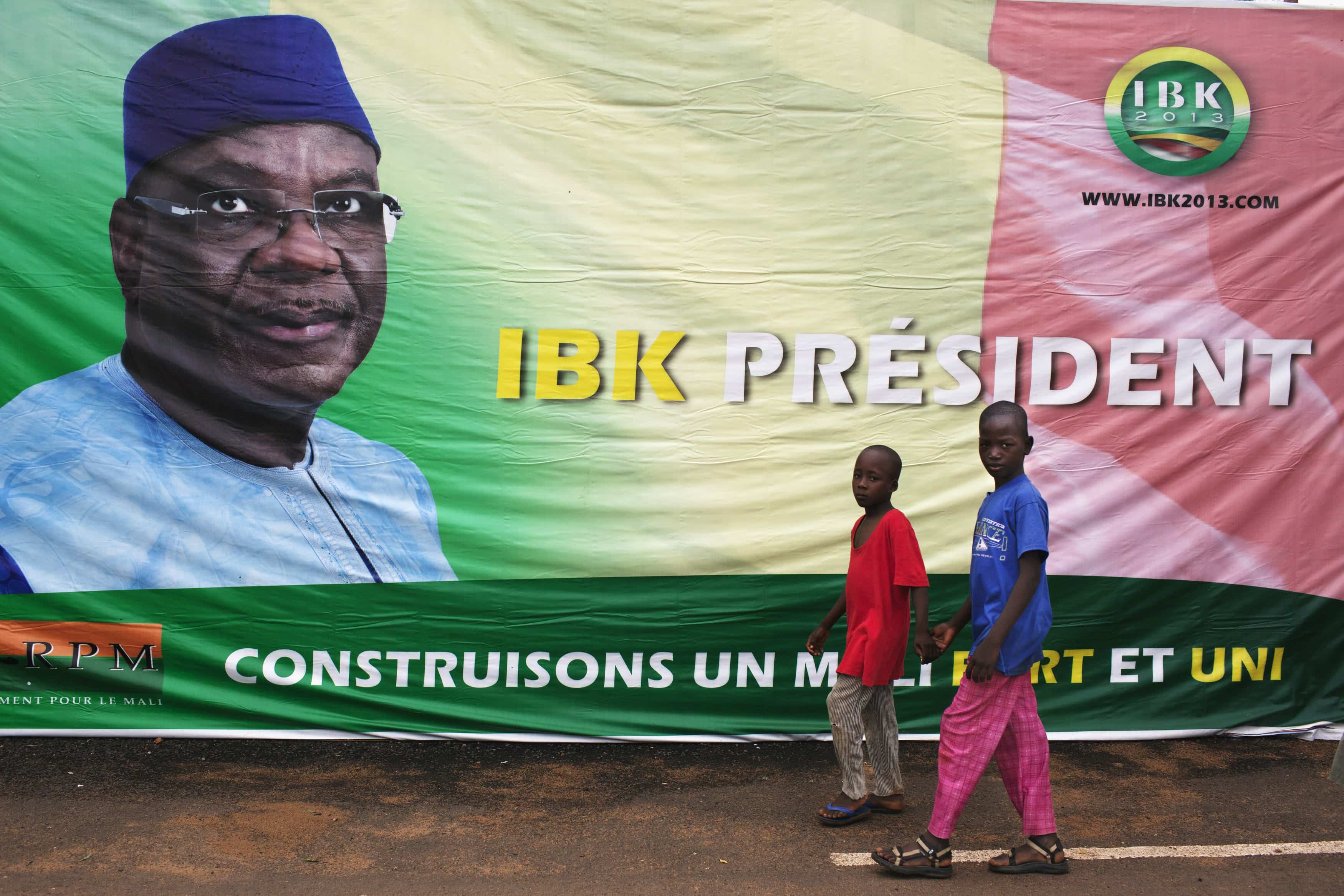 Boys walk in front of a poster of Mali's President-elect Ibrahim Boubacar Keita in Bamako, 13 August 2013. , REUTERS/Joe Penney