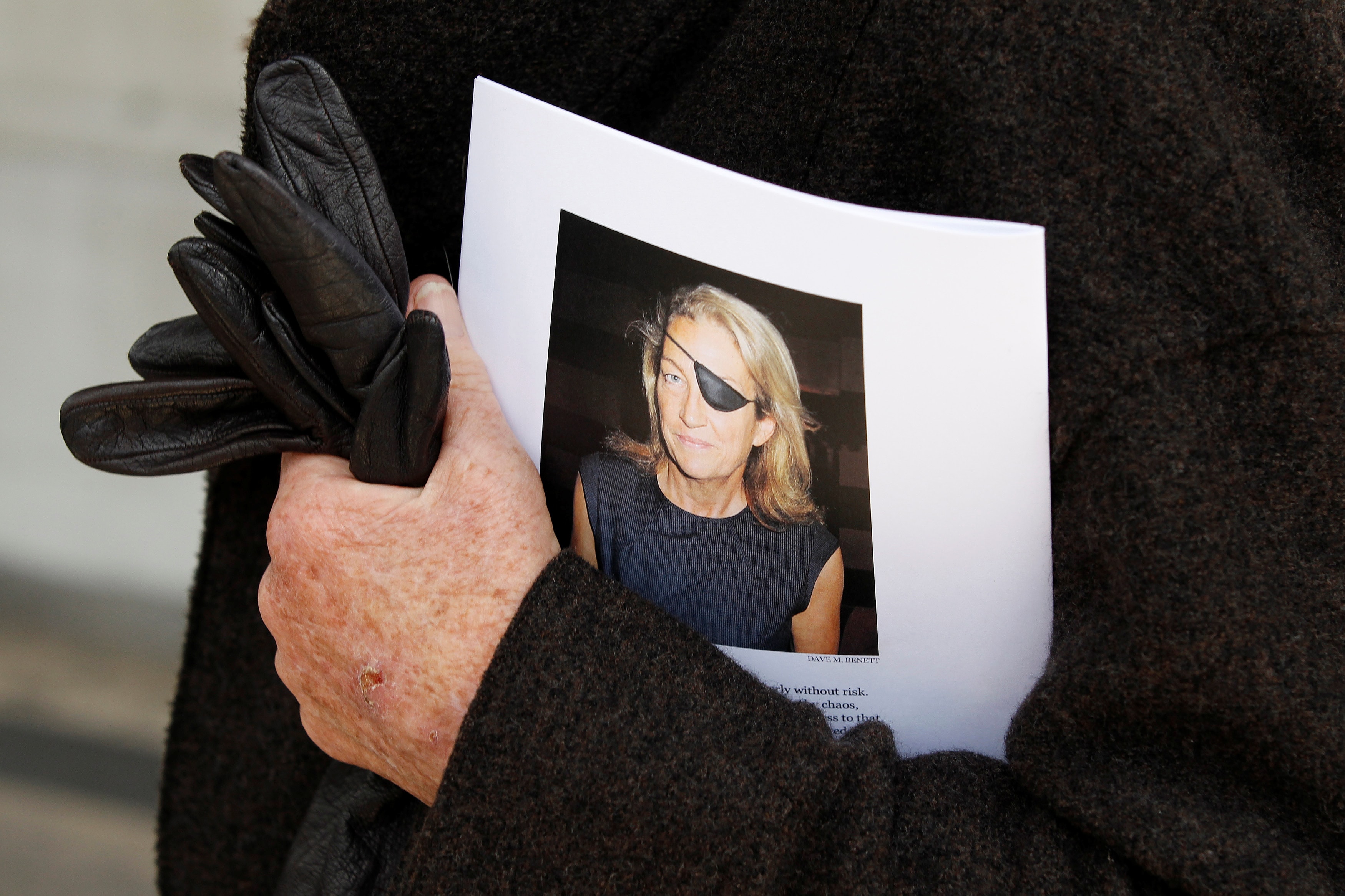A man holds a sign honoring Sunday Times journalist Marie Colvin after a memorial service, outside St Martin in the Field in London May 16, 2012, REUTERS/Stefan Wermuth/File Photo