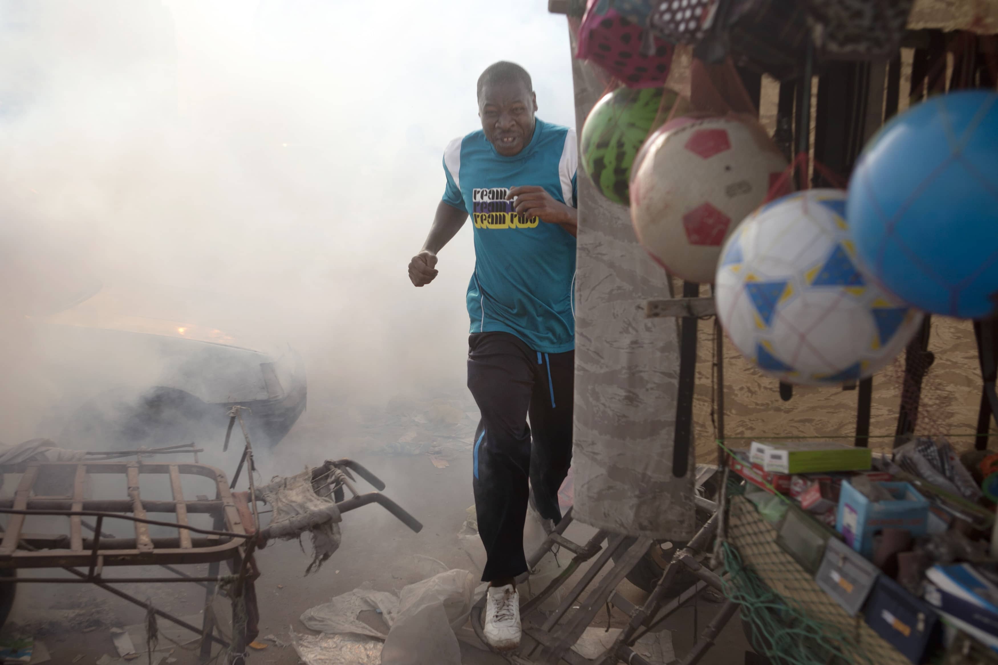 A man runs from tear gas fired by police during an anti-slavery demonstration to demand the liberation of imprisoned abolitionist leader Biram Ould Abeid in Nouakchott, 26 May 2012, REUTERS/Joe Penney