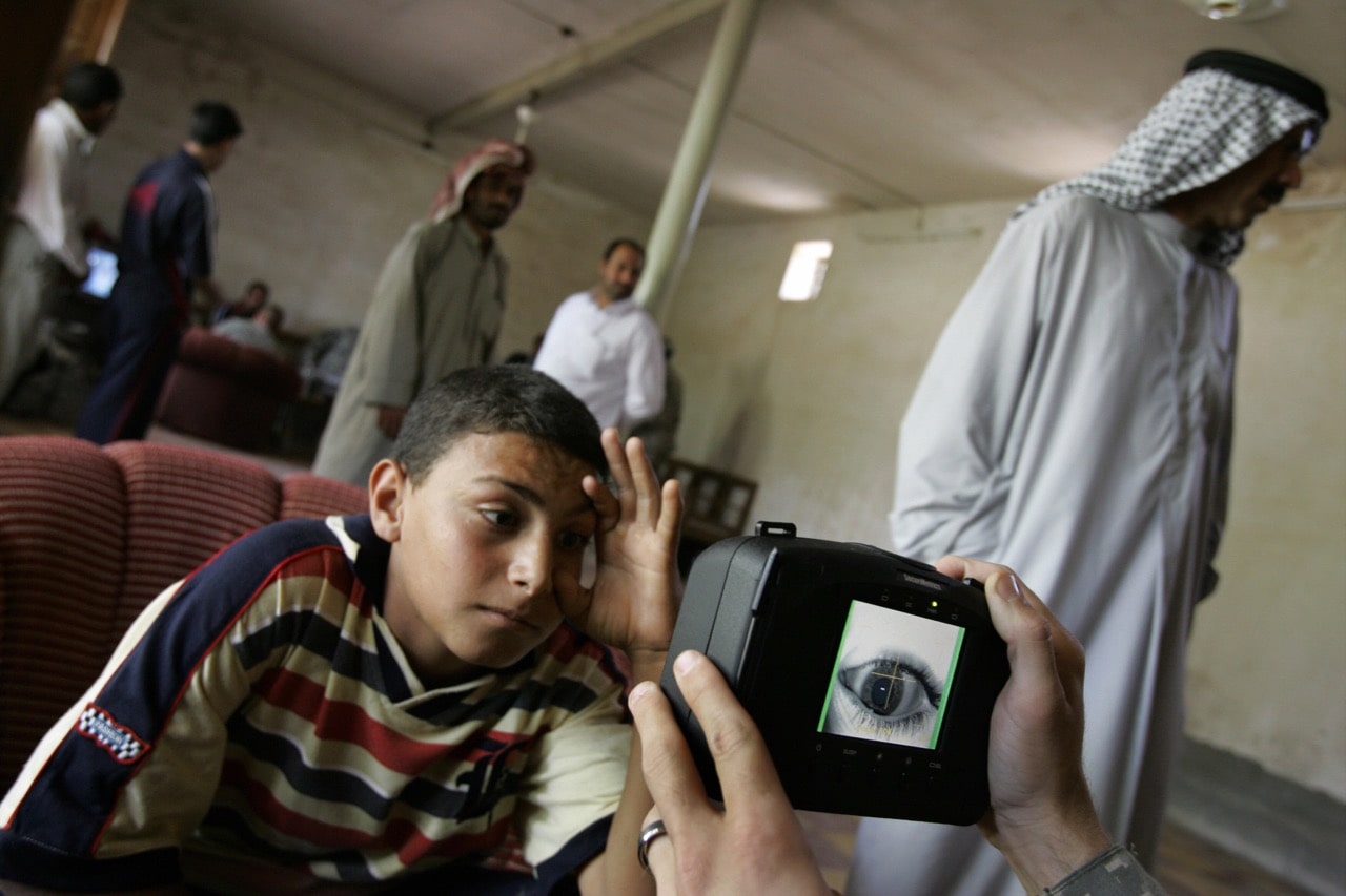 An Iraqi youth stretches his eye as a US soldier scans his iris using a biometrics digital system camera in Mahmudiyah, south of Baghdad, 5 May 2008, MAURICIO LIMA/AFP/Getty Images