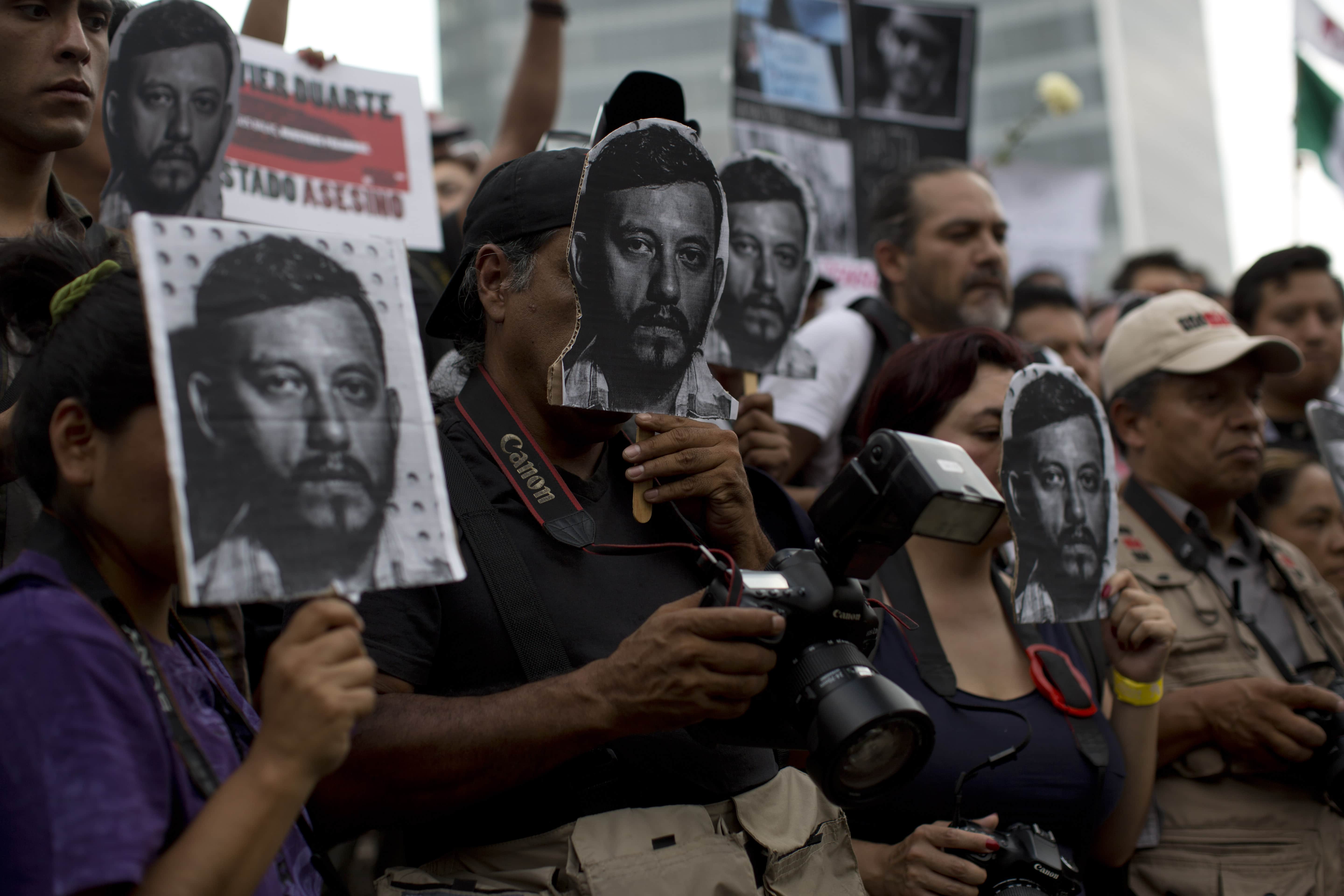 Journalists and activists hold up cut-out images of slain photojournalist Ruben Espinosa during a protest at Mexico City's Angel of the Independence monument, 2 August 2015, AP Photo/Dario Lopez-Mills