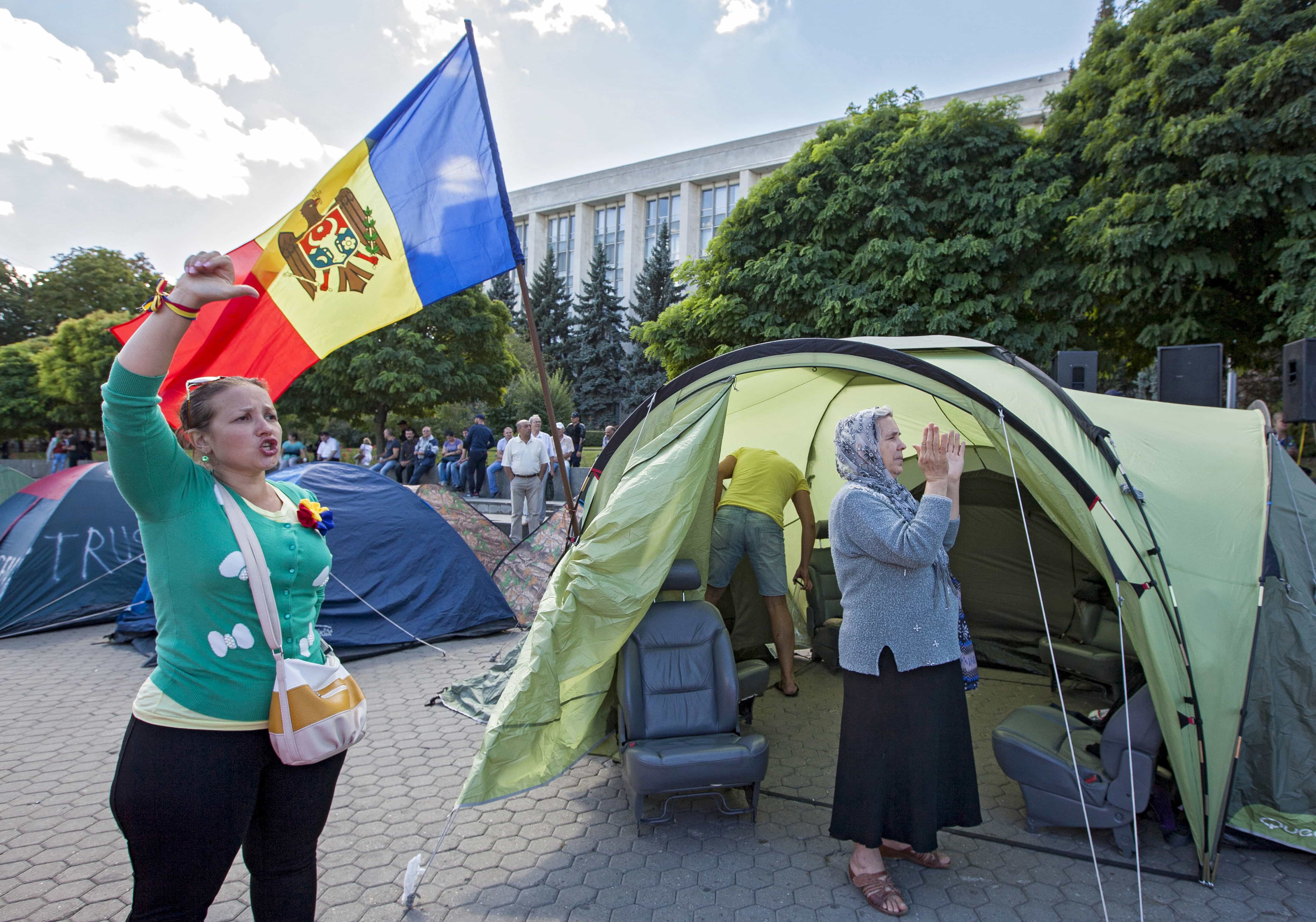 People chant slogans as they stand in front of the tents set by protesters after an anti-government rally, organised by the civic platform "Dignity and Truth" (DA), in Chisinau, Moldova, 7 September 2015, REUTERS/Viktor Dimitrov
