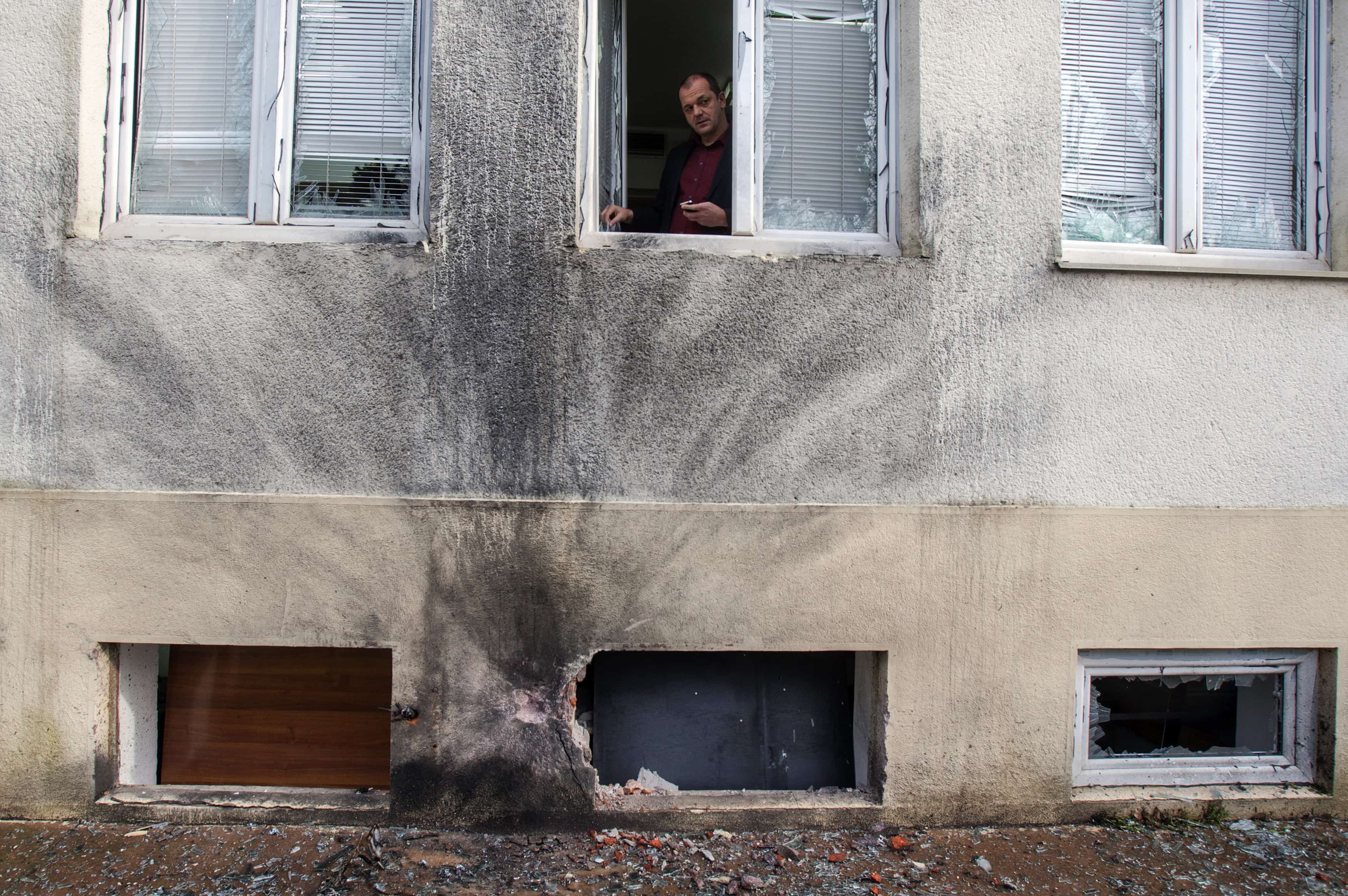 Mihailo Jovovic, the editor-in-chief of Vijesti, looks through a window damaged in a bomb blast overnight at the newspaper's offices, 27 December 2013., REUTERS/Stevo Vasiljevic