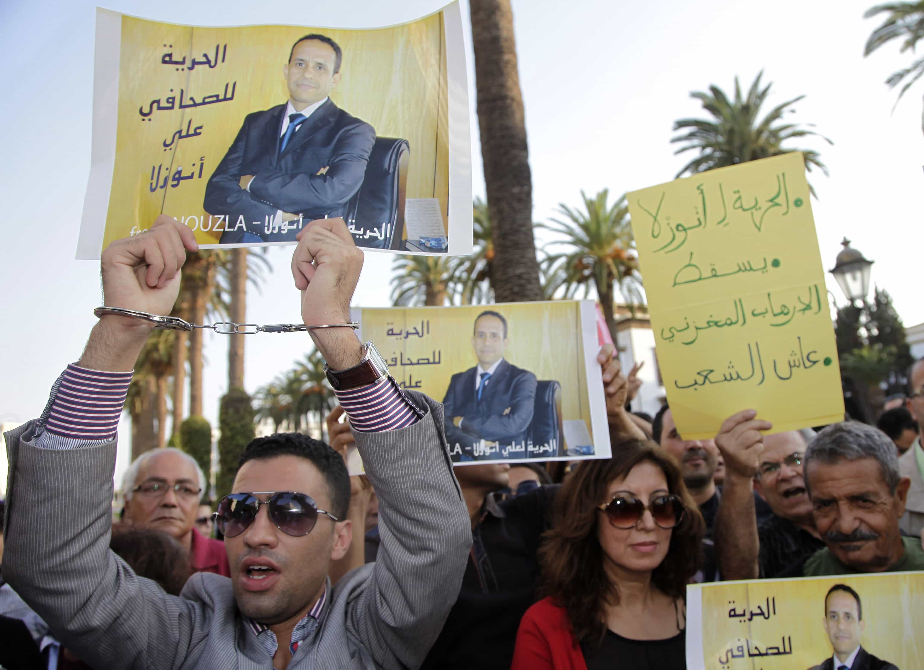 Demonstrators hold signs and posters of Moroccan editor Ali Anouzla during a protest against his arrest on 26 September. Anouzla was arrested after posting posting a link to a video from al Qaeda, REUTERS/Stringer