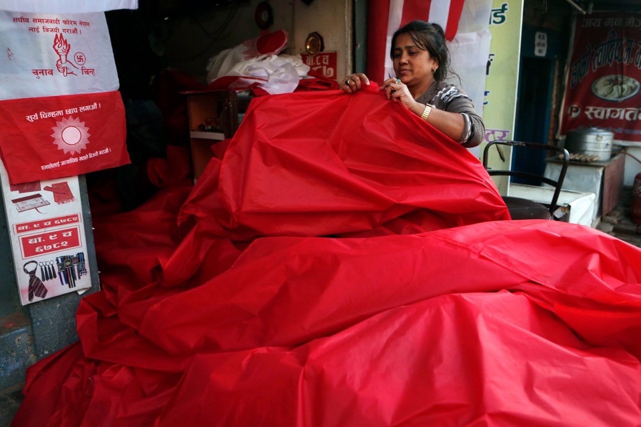 A Nepalese woman at a screen printing unit prepares to print flags of various political parties ahead of the upcoming legislative elections in Kathmandu, Nepal, 13 November 2017, AP Photo/Niranjan Shrestha