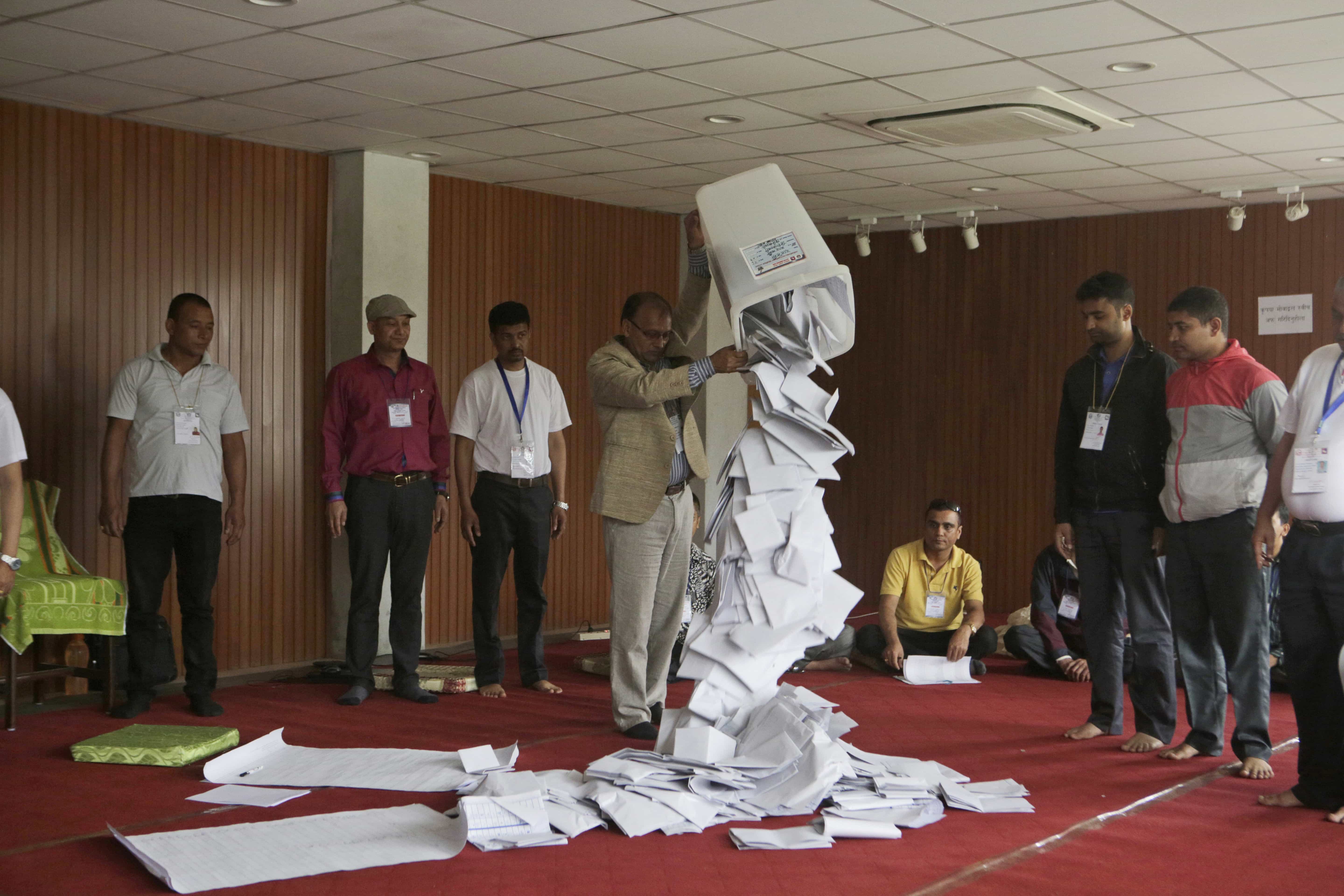 A Nepalese election commission officer empties a ballot box prior to counting the votes of local elections in Kathmandu, Nepal, 15 May 2017, AP Photo/Niranjan Shrestha