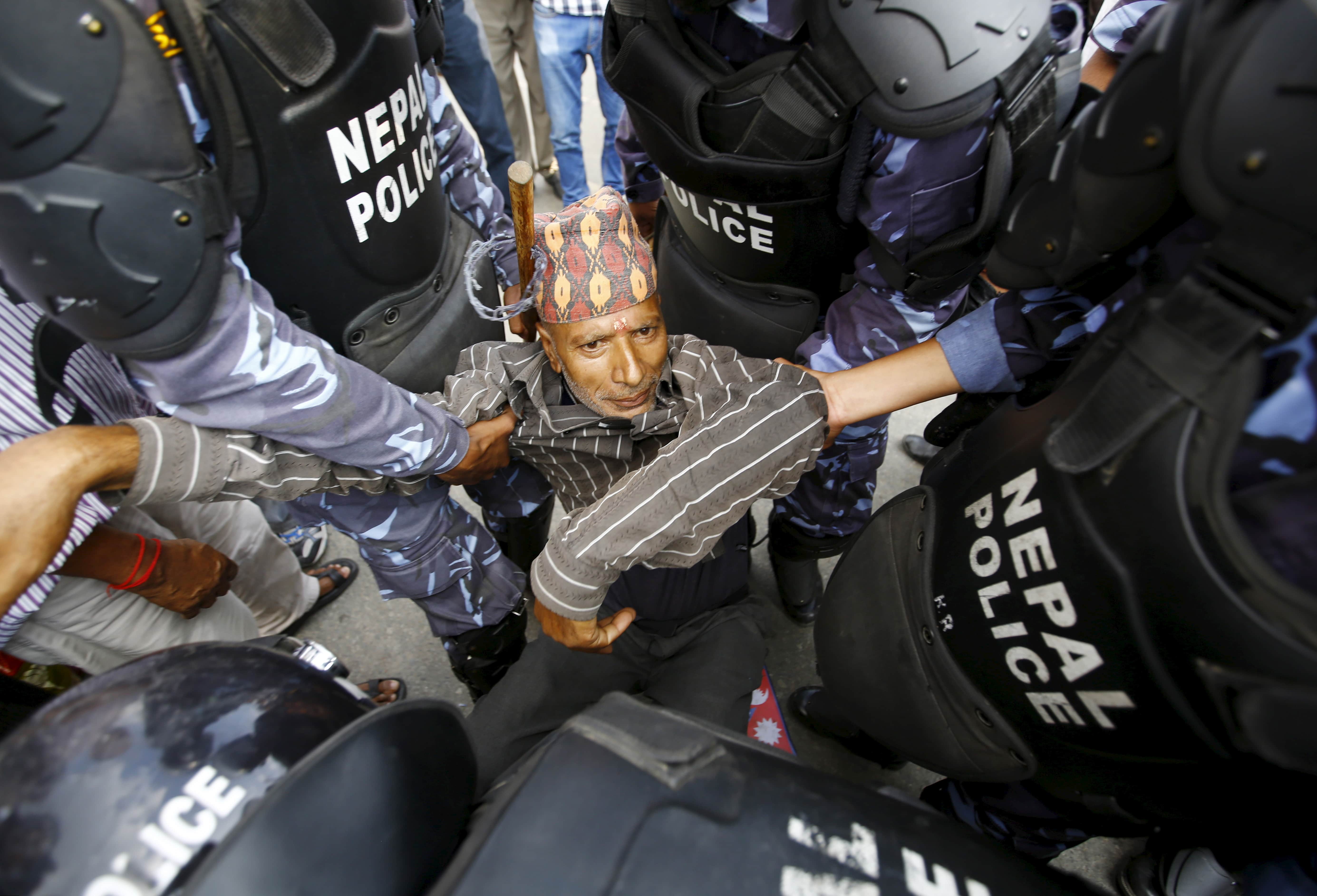 A Hindu activist blocking a road is carried away by police during a protest rally trying to break through a restricted area near the parliament in Kathmandu, Nepal, 1 September 2015. The protesters demanded Nepal be declared a Hindu state in the new Constitution, REUTERS/Navesh Chitrakar