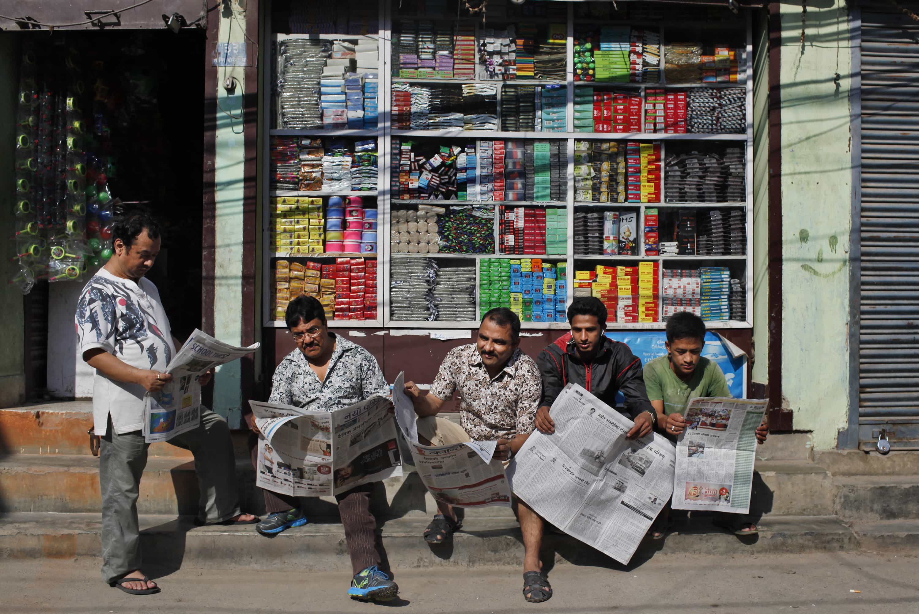 Nepalese men read newspapers outside a shop in Kathmandu, 1 October 2015, AP Photo/Niranjan Shrestha