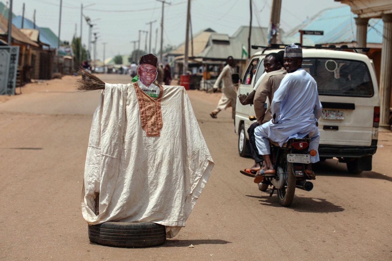 People pass by an effigy depicting the incumbent governor of Kaduna State, Mallam Nasir El-Rufai, during Nigeria's governorship and state assembly elections in Kaduna, 9 March 2019, KULA SULAIMON/AFP/Getty Images