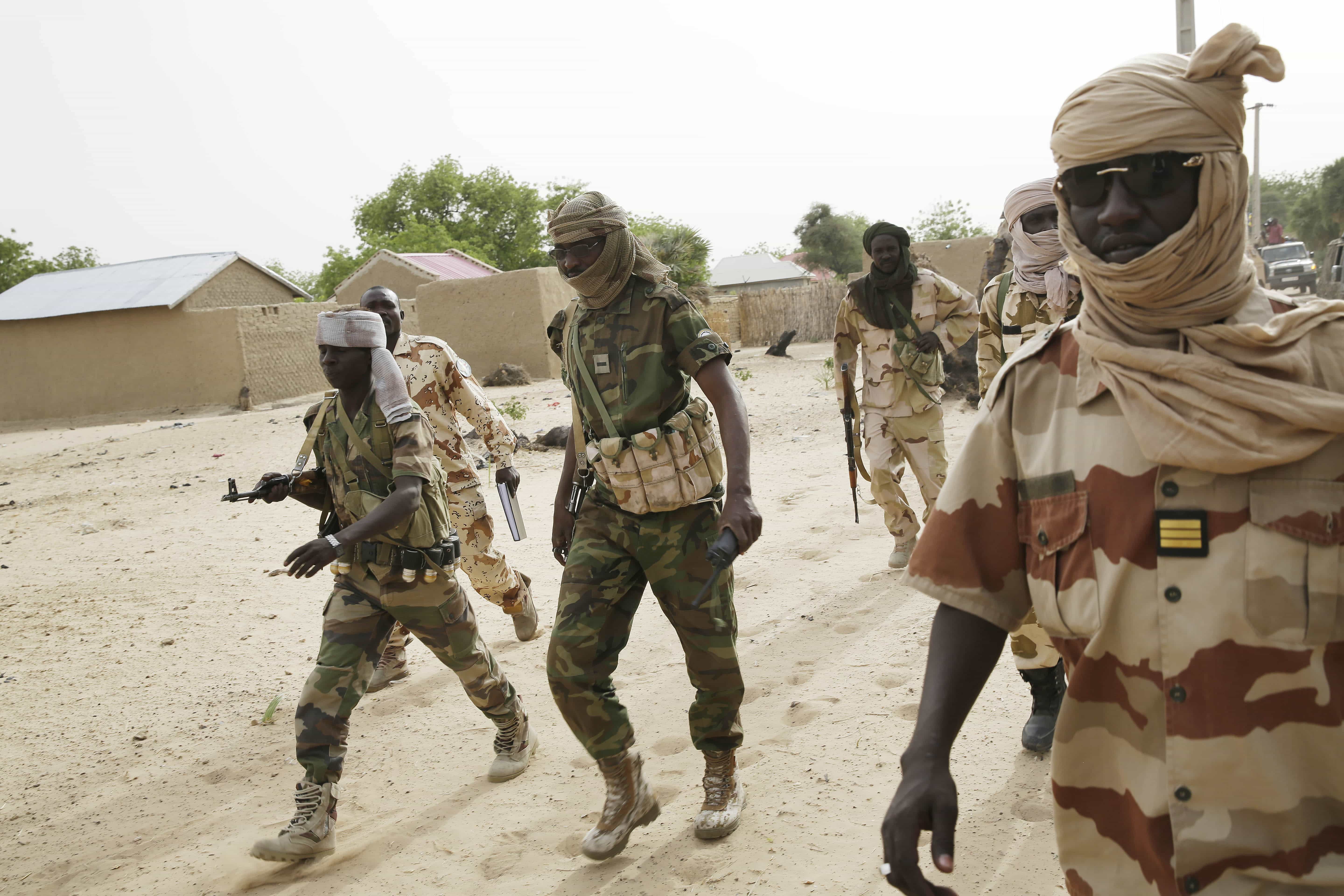 Chadian soldiers escort a group of journalists, walking in the city of Damasak, Nigeria, 18 March 2015, AP Photo/Jerome Delay