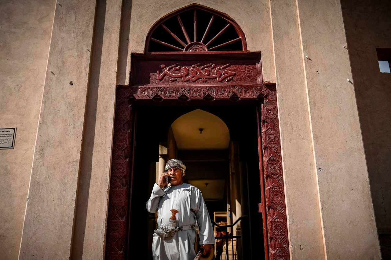 A man wearing traditional dress talks on a mobile phone outside the Nizwa fort in Muscat, Oman, 13 February 2018, PHILIPPE LOPEZ/AFP/Getty Images