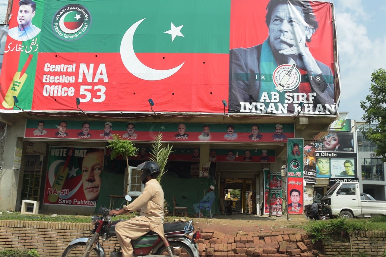A motorcyclist rides past a billboard featuring an image of Pakistan's cricketer-turned politician Imran Khan, head of the Pakistan Tehreek-e-Insaf (Movement for Justice) party, a day after the general election in Islamabad, 26 July 2018, AAMIR QURESHI/AFP/Getty Images