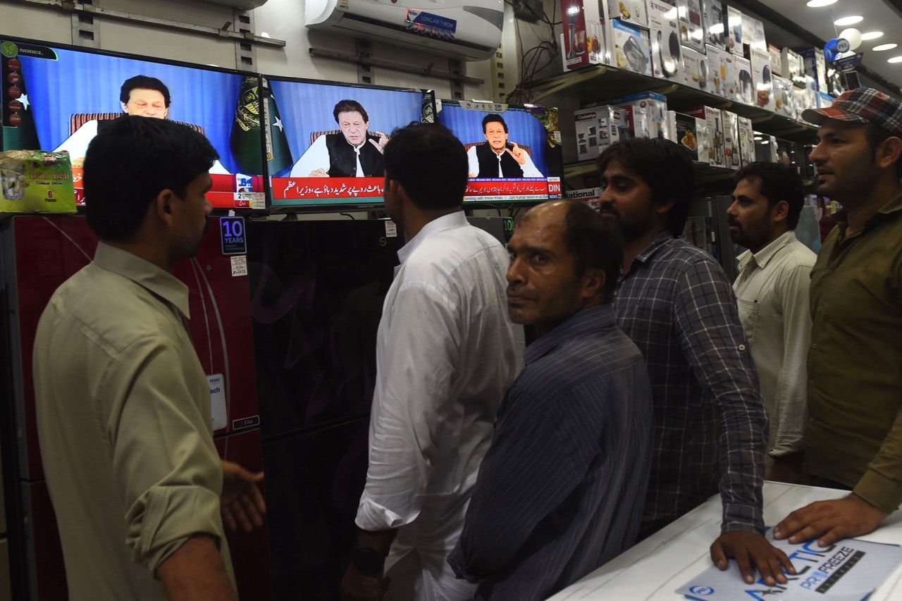 Pakistani men gather in a store as they watch a broadcast of a speech by newly appointed Prime Minister Imran Khan, in Lahore, 19 August 2018