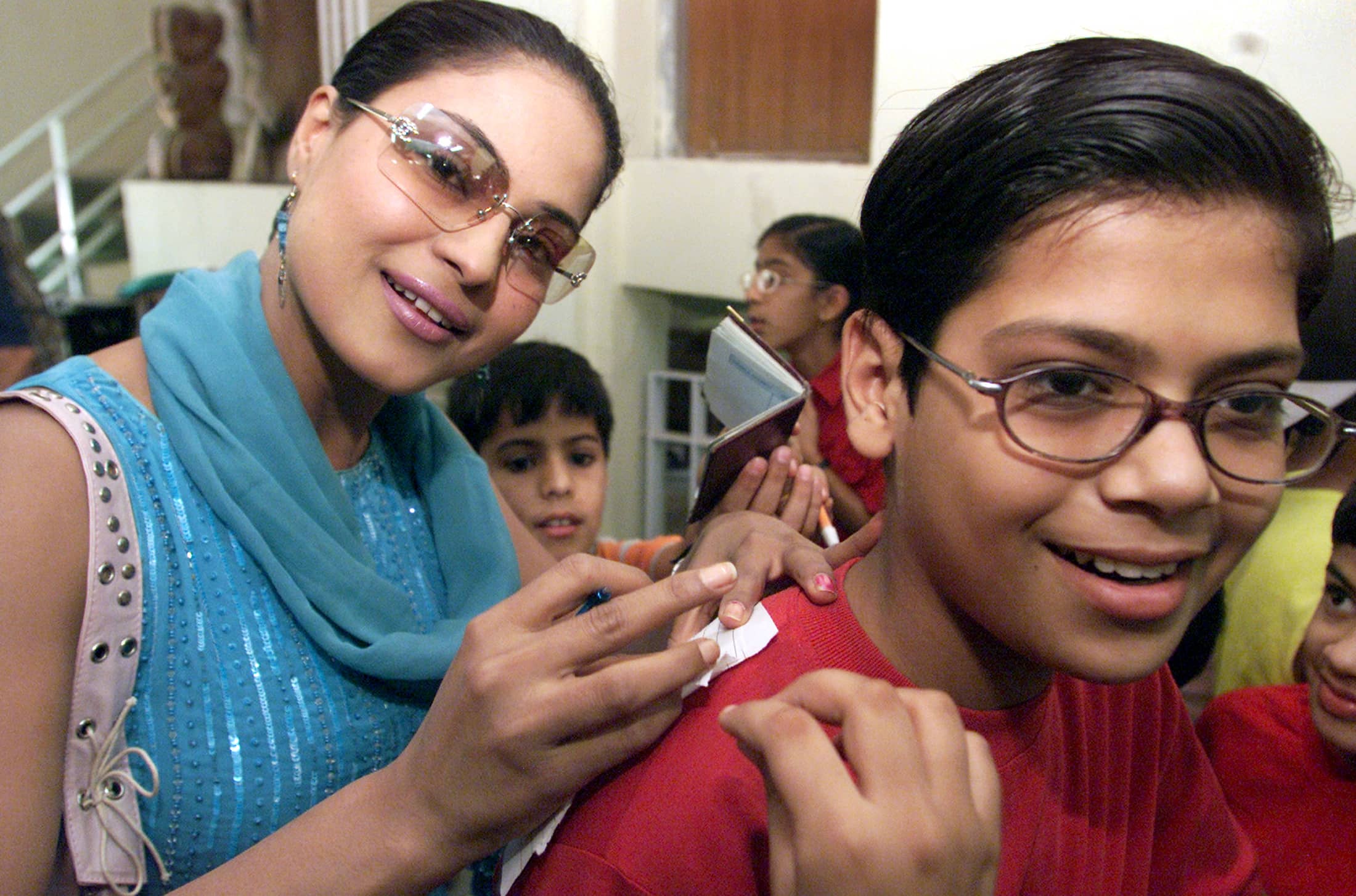 One of the accused, Pakistani actress Veena Malik, signs autographs for Indian school children in Chandigarh, India, 27 May 2004, REUTERS/Ajay Verma
