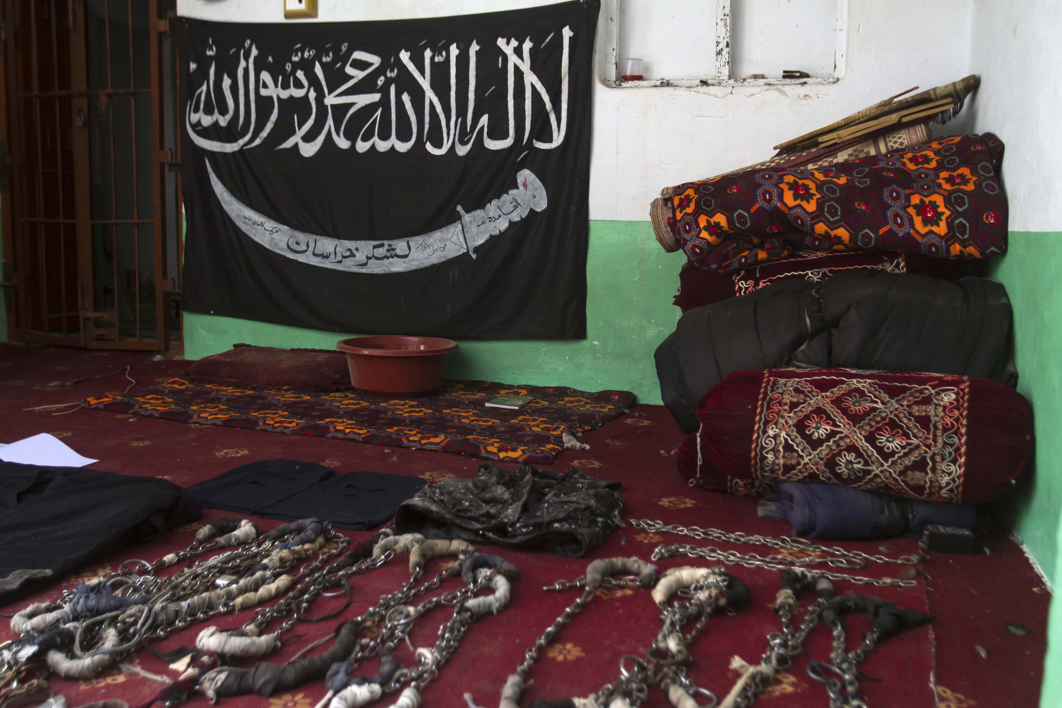 A black Jihad flag, handcuffs and chains are displayed in a house used by Taliban militants as a prison after a military operation against the militants in the town of Miranshah in North Waziristan, 9 July 2014, REUTERS/Maqsood Mehdi