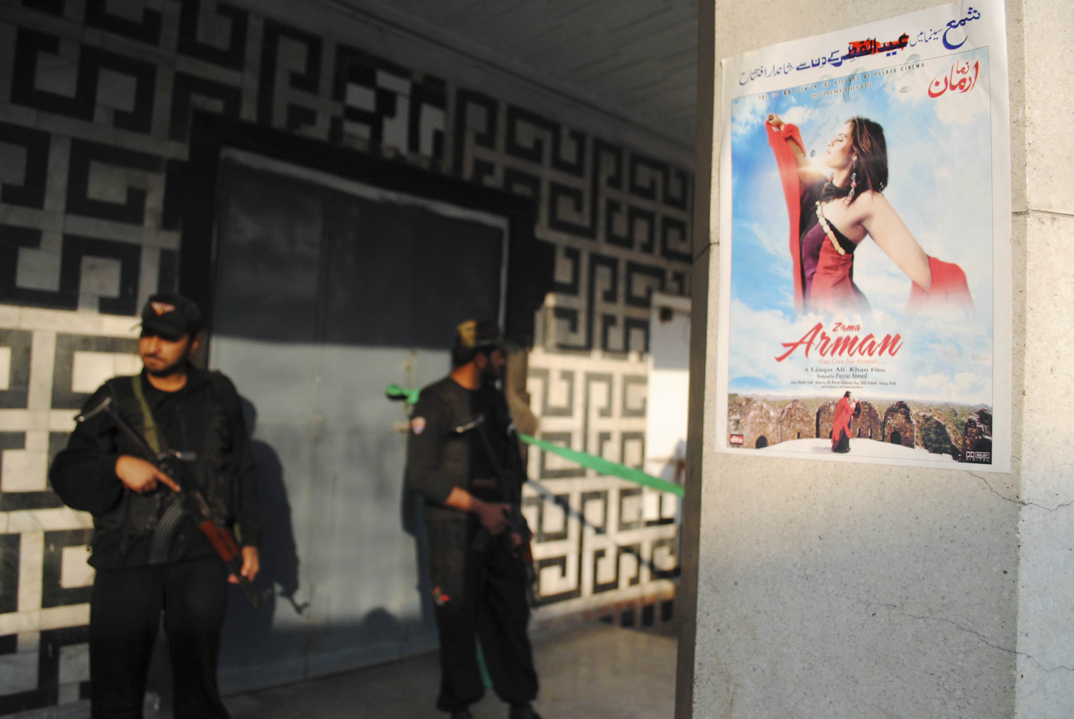 The poster of a Pashto language film is pictured as policemen guard the entrance of a cinema at the site of a grenade attack in Peshawar, 11 February 2014, REUTERS/Khuram Parvez