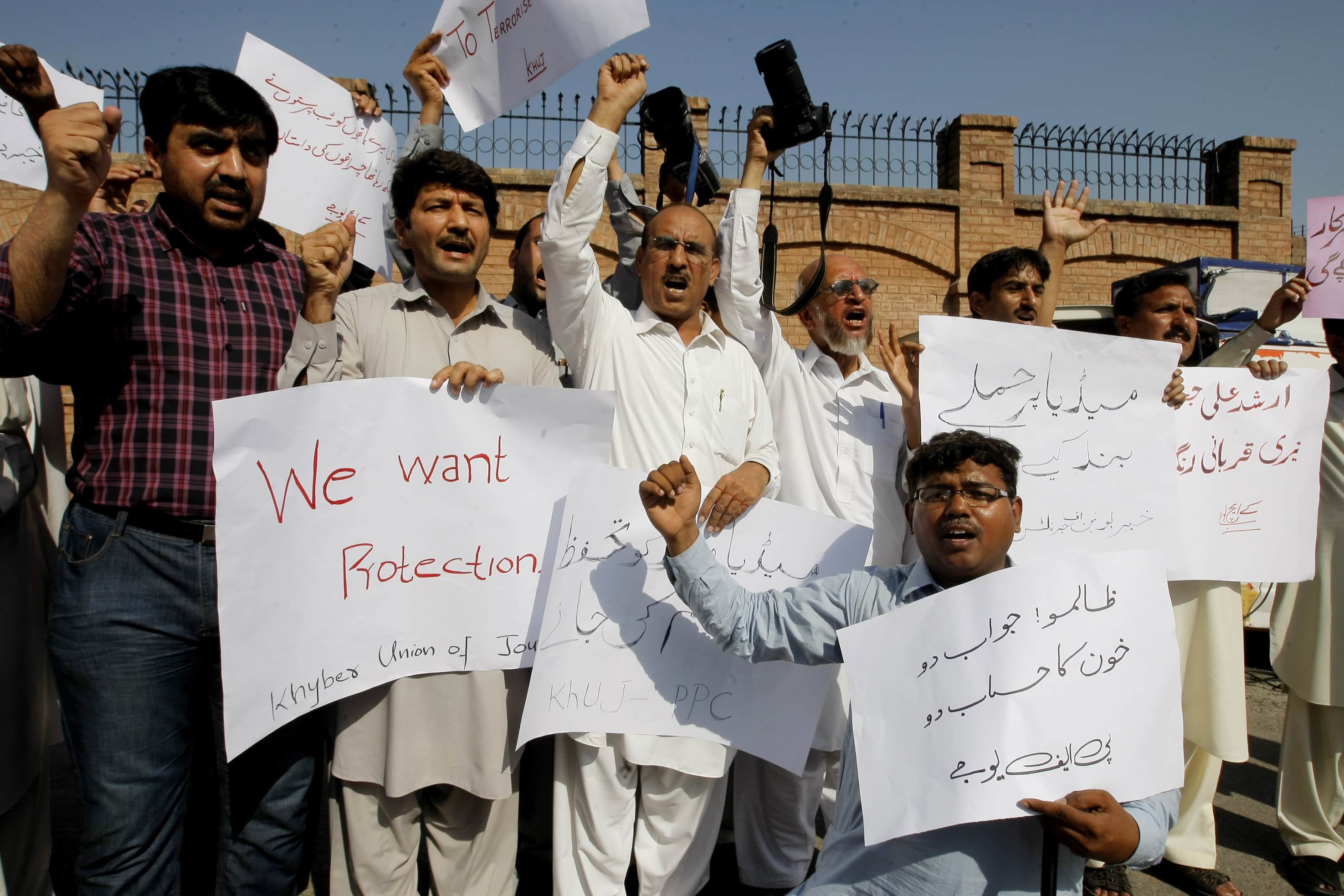 Pakistani journalists shout slogans to condemn the killing of journalists, Wednesday, 9 September 2015 in Peshawar, Pakistan. Placard on right reads "stop attacks on media.", AP Photo/Mohammad Sajjad