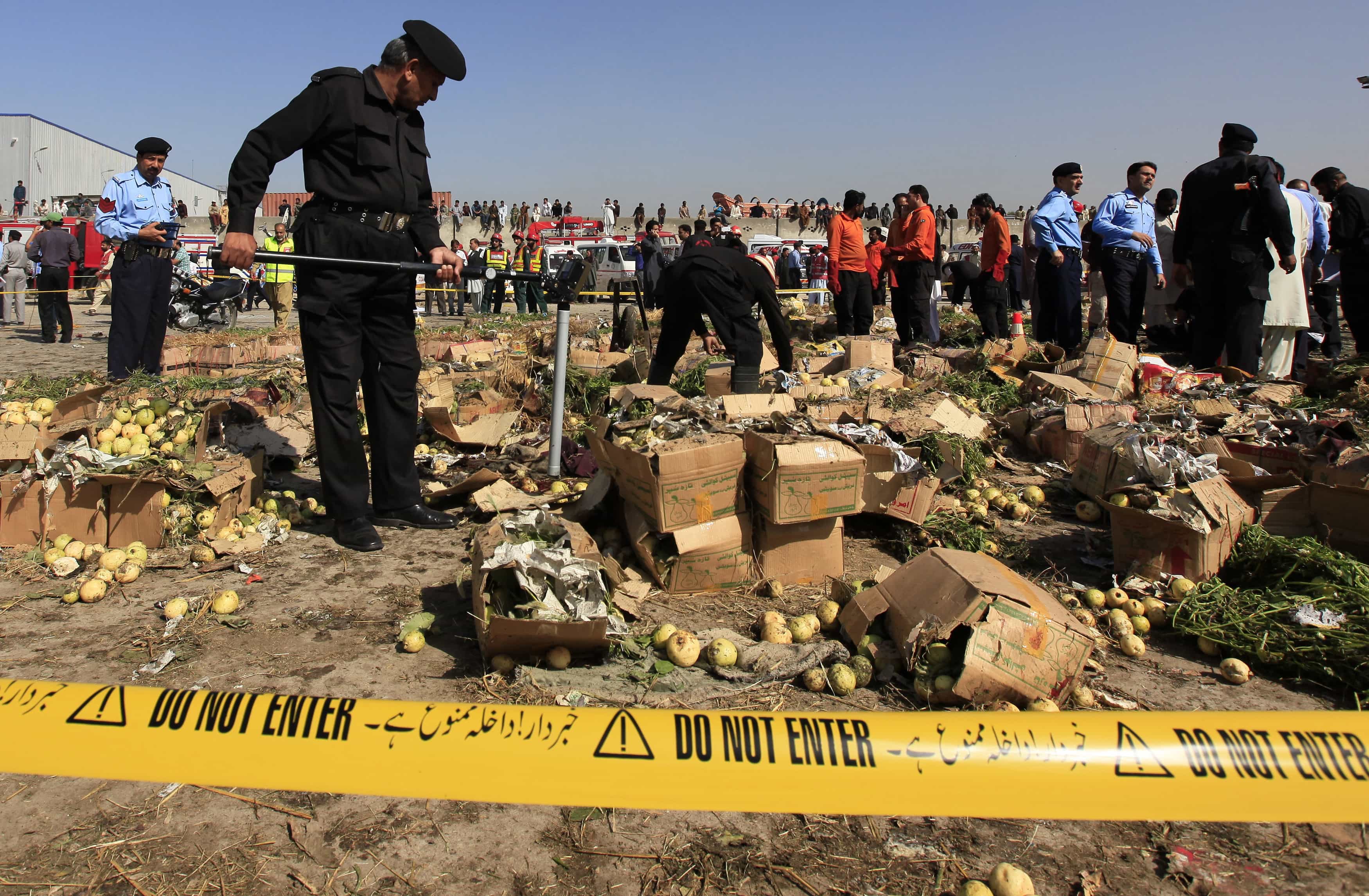 A police official uses a metal detector to search the site of a bomb blast at a vegetable and fruit market in the outskirts of Islamabad, 9 April 2014, REUTERS/Mian Khursheed