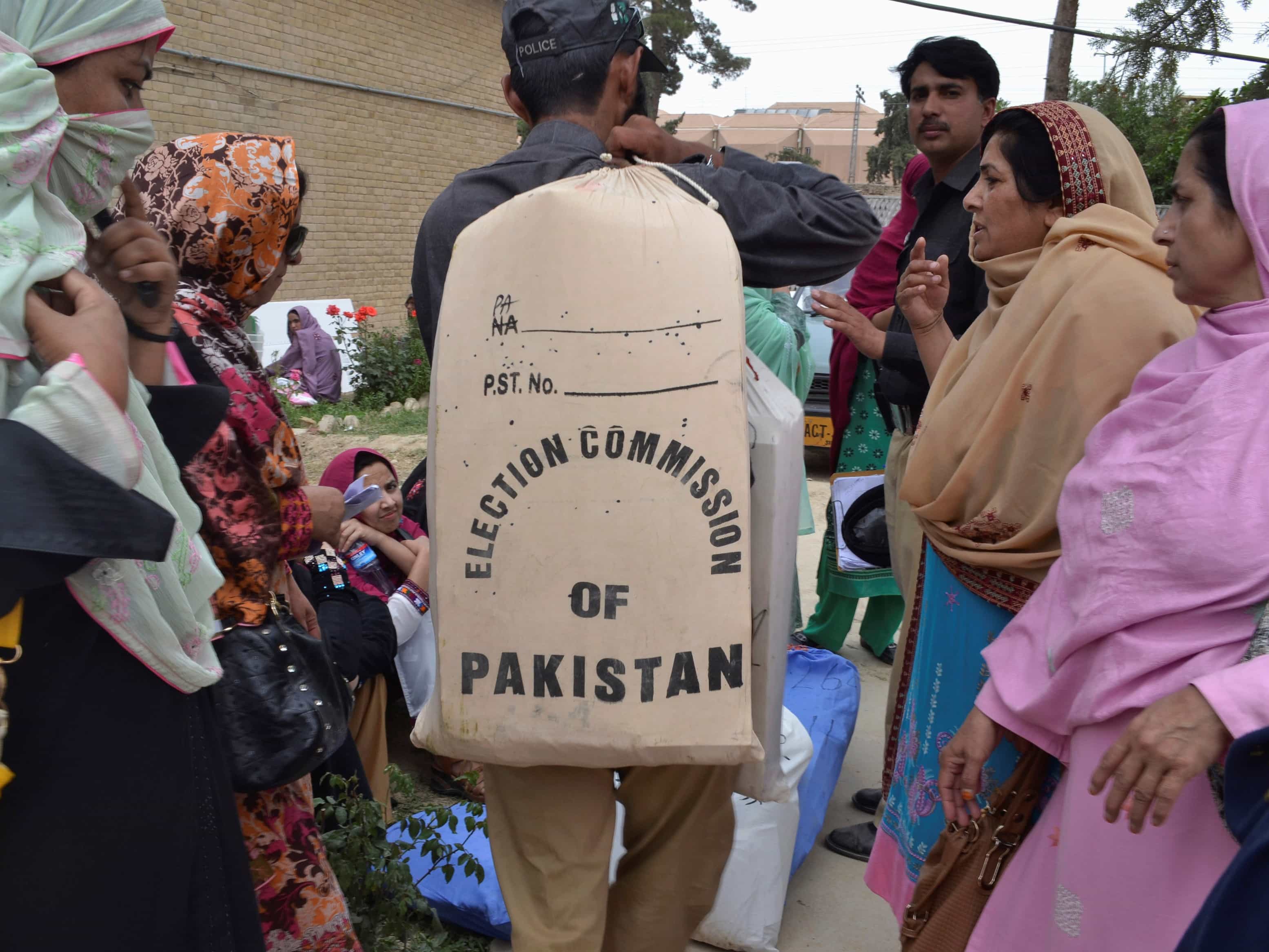 A policeman carries a sack containing stationery before transporting it to a polling station, at a college used as a storage area for election material, in Quetta 10 May 2013, REUTERS/Naseer Ahmed