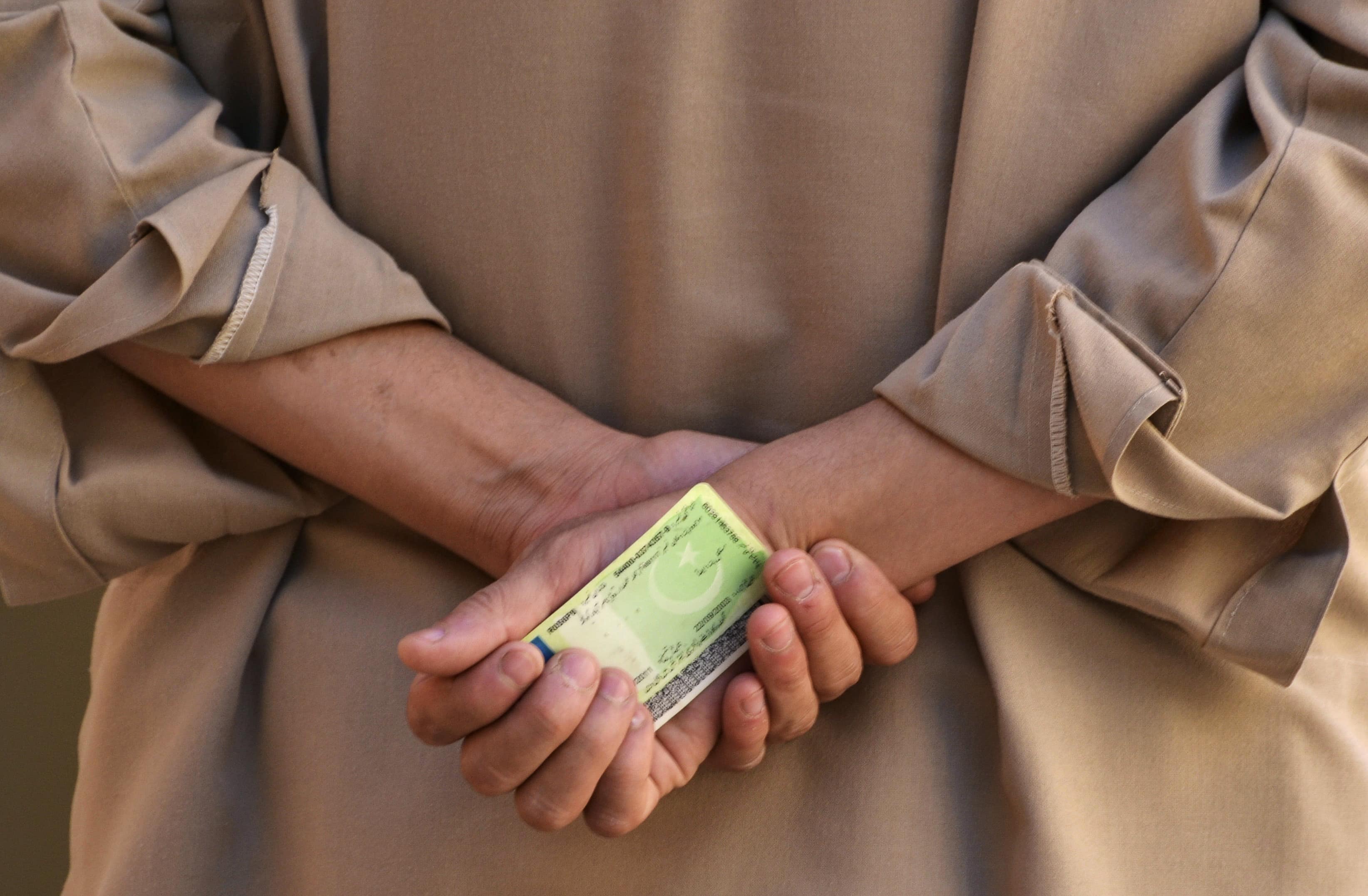 A voter holds his CNIC as he waits to cast his vote at a polling station in Quetta, 11 May 2013, REUTERS/Naseer Ahmed