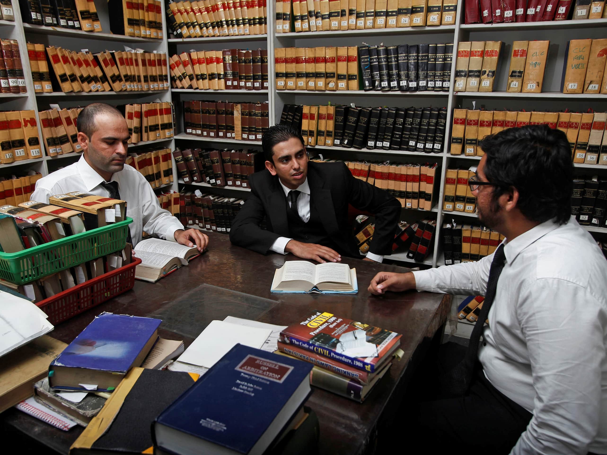 Lawyer Yasser Latif Hamdani (C) speaks with colleagues at his office in Lahore, 18 September 2013; Hamdani is suing the Pakistani government on behalf of Internet freedom activists, REUTERS/Mohsin Raza