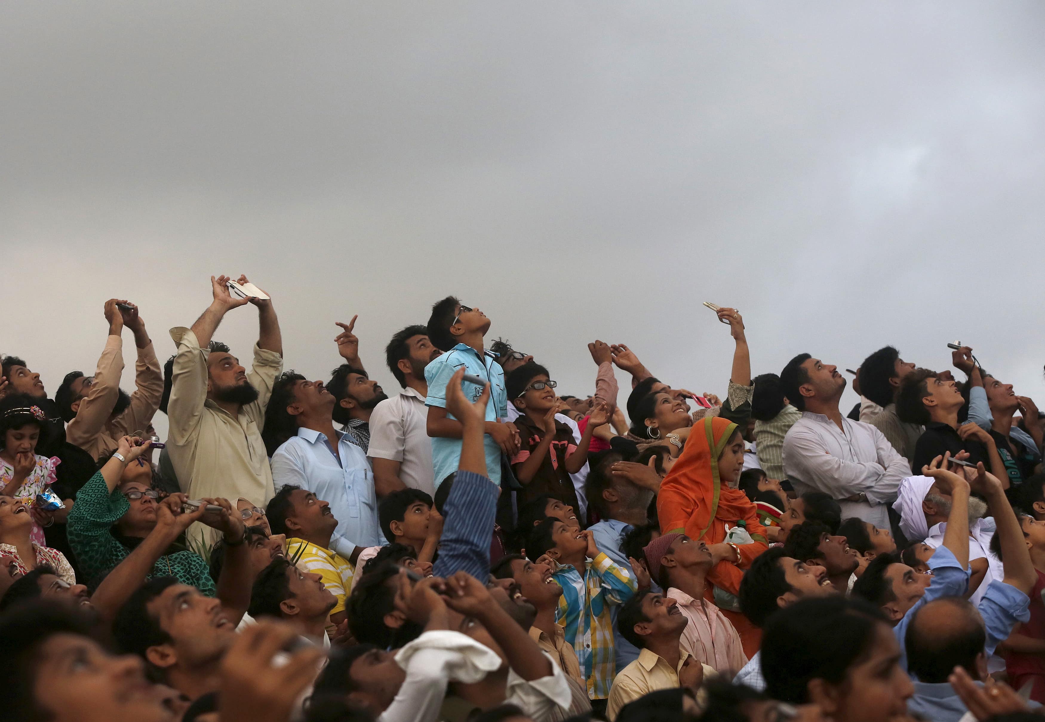 People take pictures with their mobile phones of paratroopers during a ceremony to mark Pakistan's Defence Day, or Memorial Day, in Karachi, Pakistan, 6 September 2015, REUTERS/Akhtar Soomro