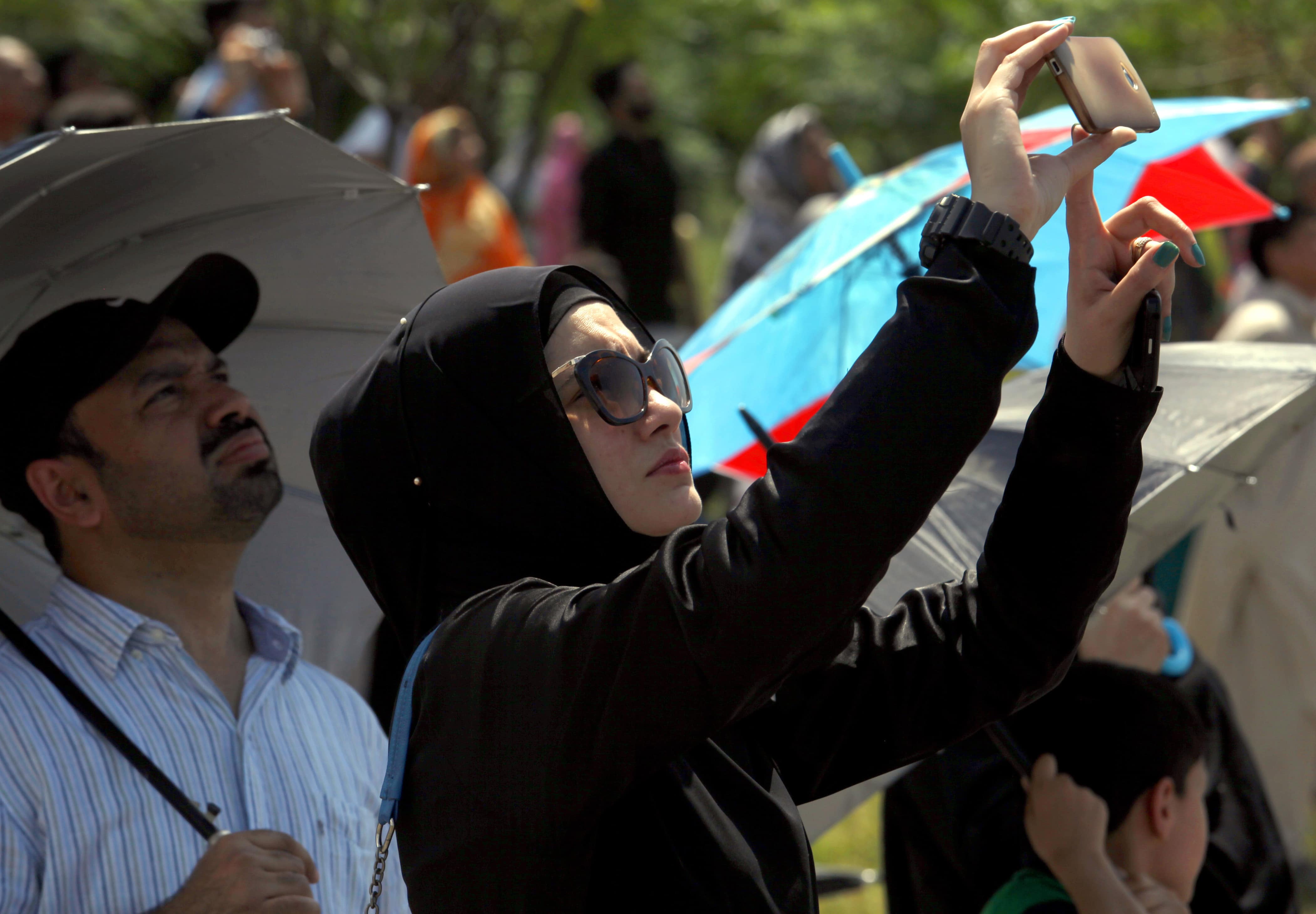 A Pakistani woman uses her mobile phone to take a photograph of a fighter aircraft during a ceremony in Islamabad, 6 September 2015, AP Photo/Anjum Naveed