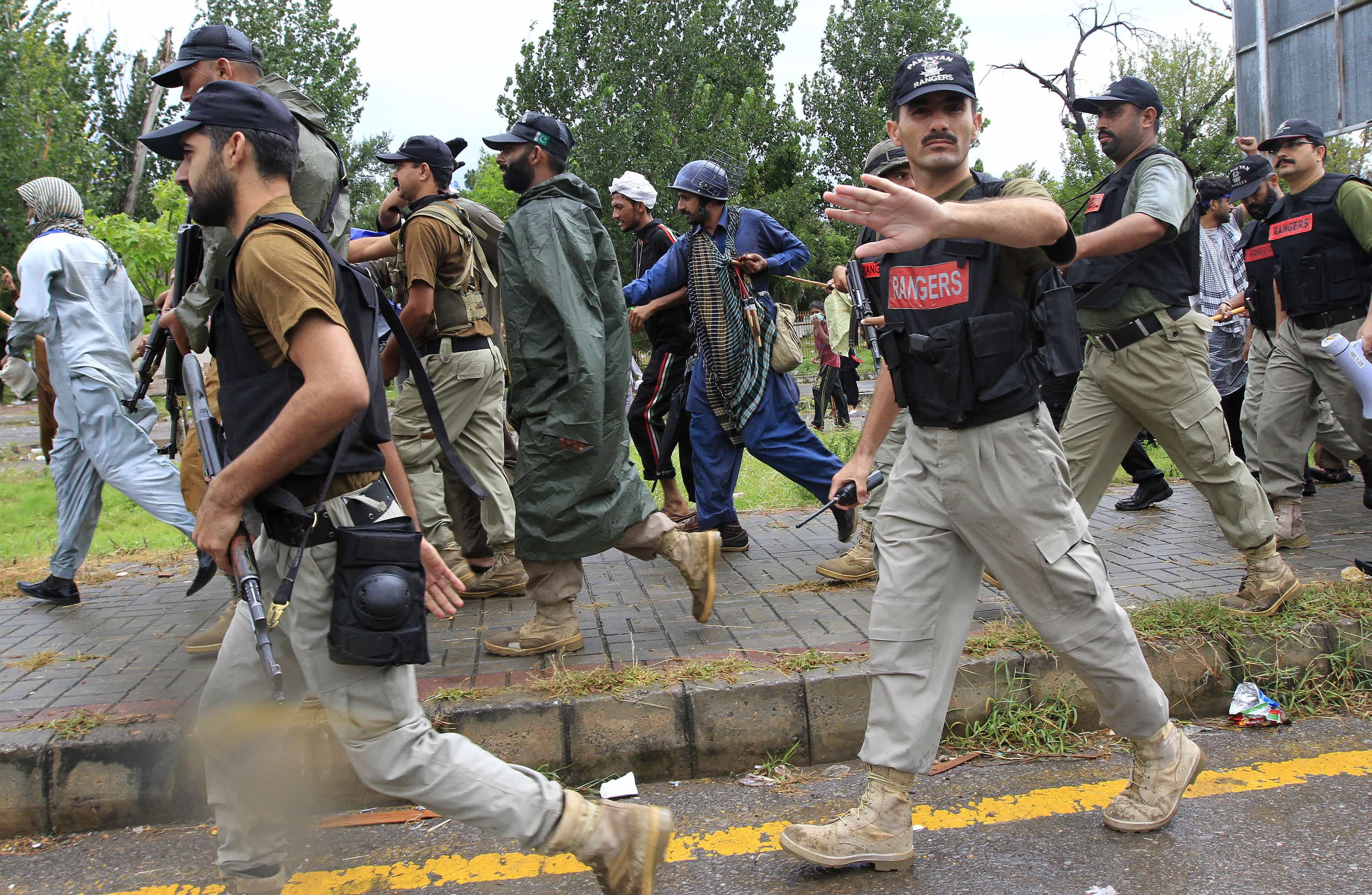 A soldier from the Pakistan Rangers gestures to stop members of the media while walking with supporters of Sufi cleric and PAT leader Tahir ul-Qadri, during a march towards the prime minister's house in Islamabad, 1 September 2014, REUTERS/Faisal Mahmood