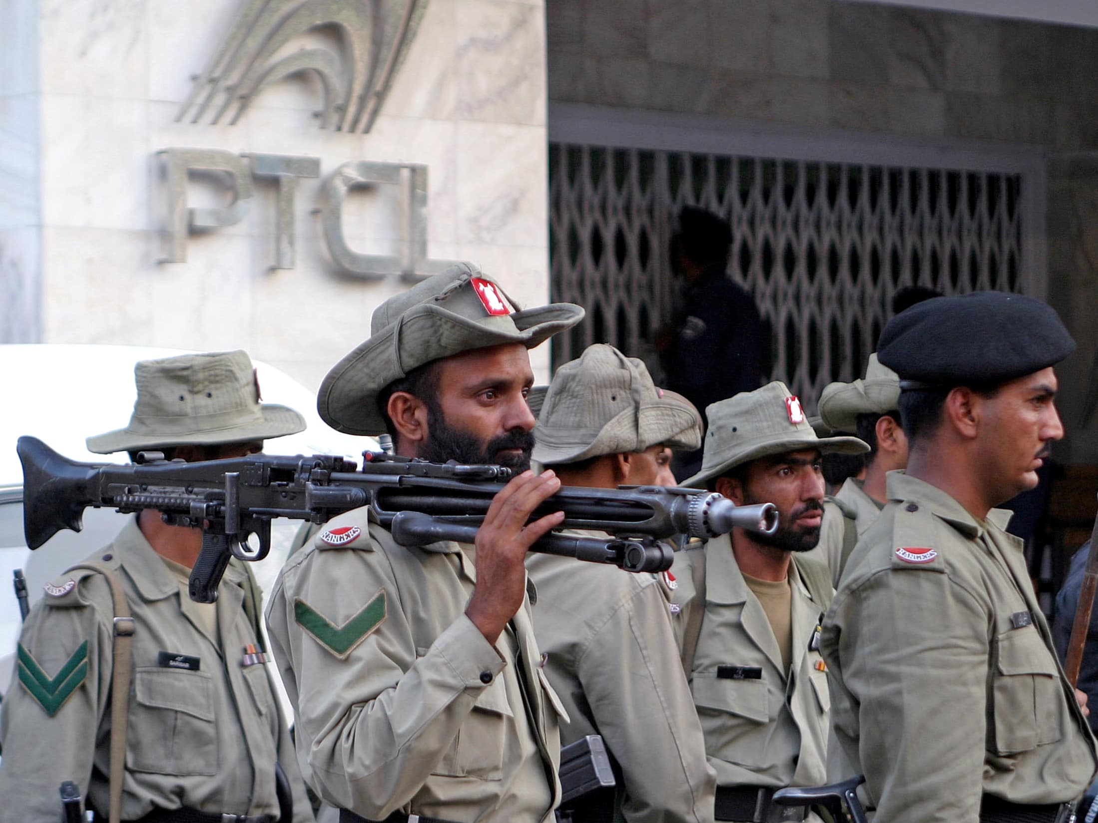 Soldiers stand guard in front of a building of the Pakistan Telecommunication Company Limited (PTCL) in Lahore, June 2005, REUTERS/Mohsin Raza