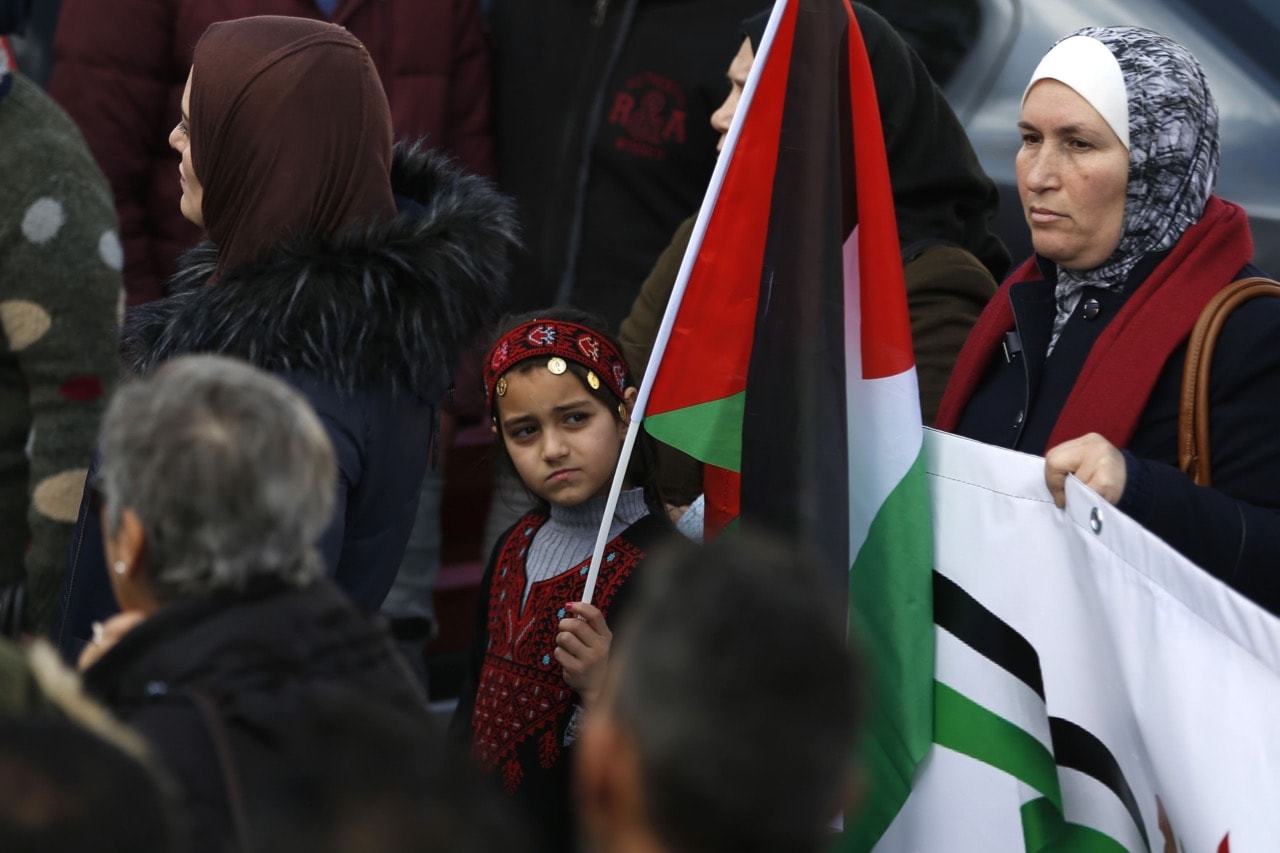 Palestinians carry national flags as they march in the streets of Ramallah, calling for the cessation of divisions between Fatah and Hamas and the unification of the West Bank and Gaza Strip, 12 January 2019, ABBAS MOMANI/AFP/Getty Images