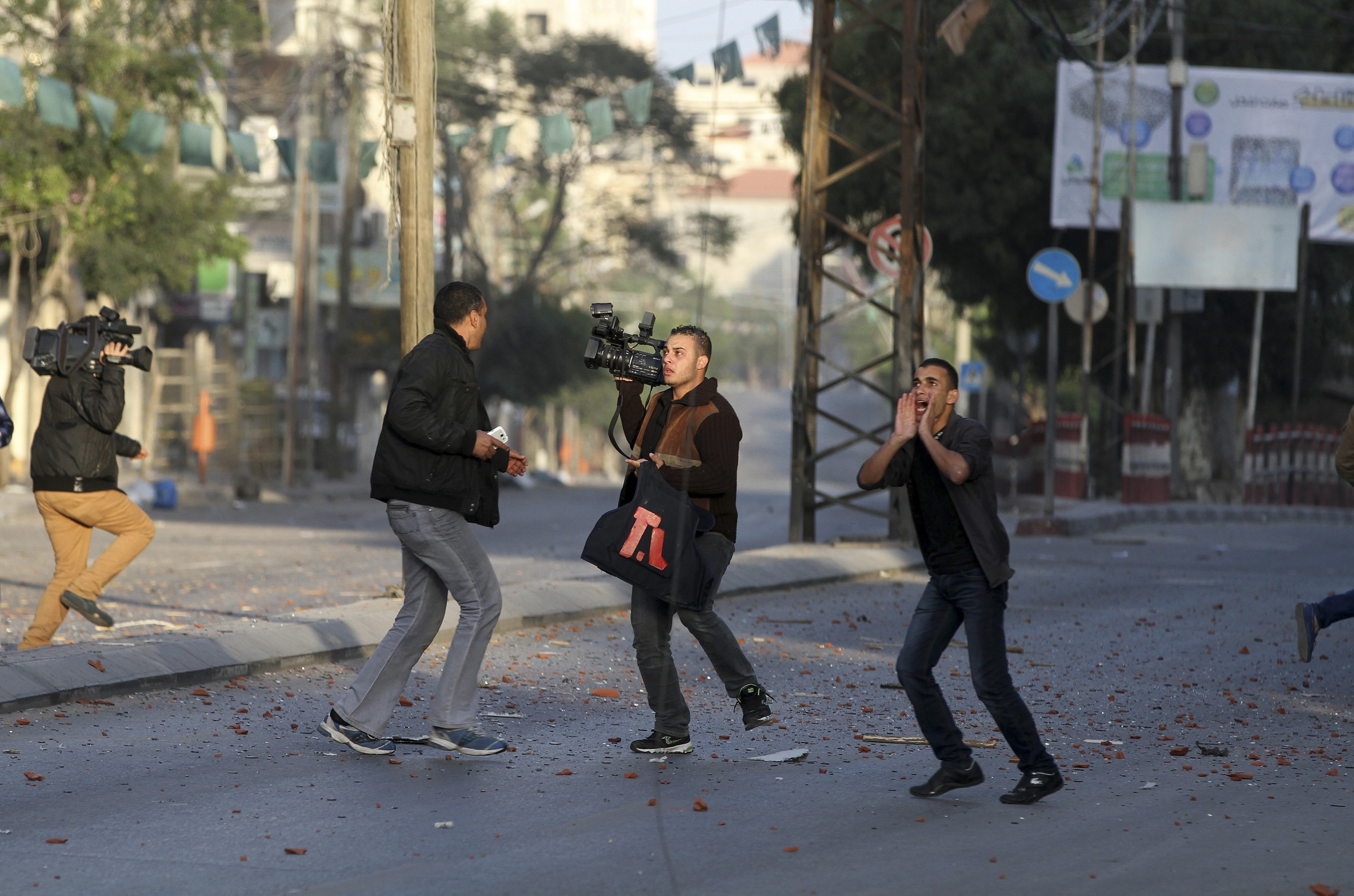 Palestinian journalists react after an Israeli air strike lands on the office of Hamas television channel Al-Aqsa in a building that also houses other media in Gaza City November 18, 2012, REUTERS/Stringer