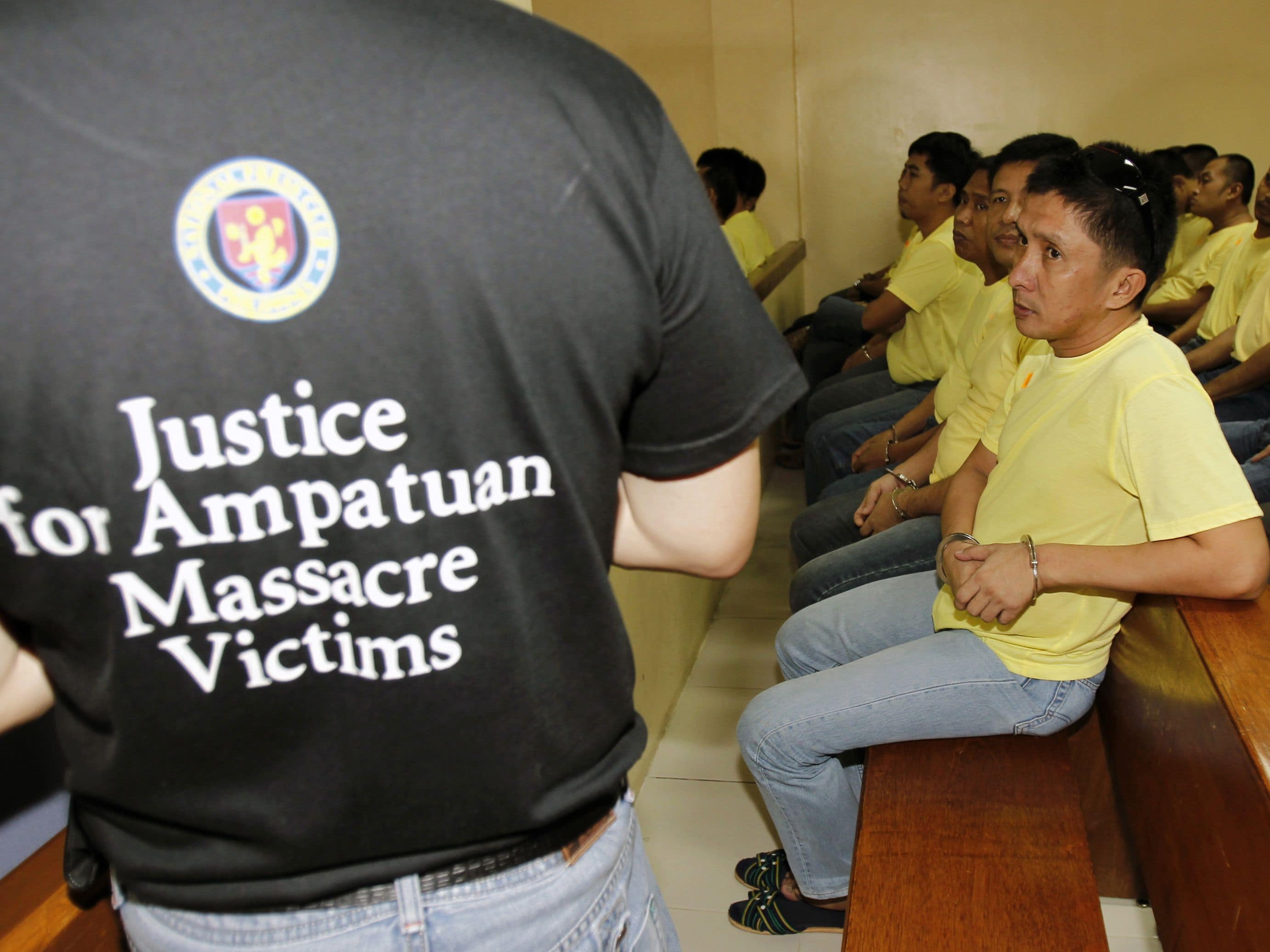 A journalist (L) stands in front of policemen during the trial of Andal Ampatuan Jr. at a court in the police headquarters in Taguig city, south of Manila, 17 November 2010, REUTERS/Romeo Ranoco