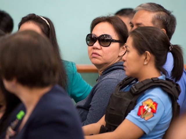 Businesswoman Janet Lim Napoles, center in sunglasses, during her arraignment at an anti-graft court, north of Manila, 30 June 2014, AP Photo/Noel Celis, Pool