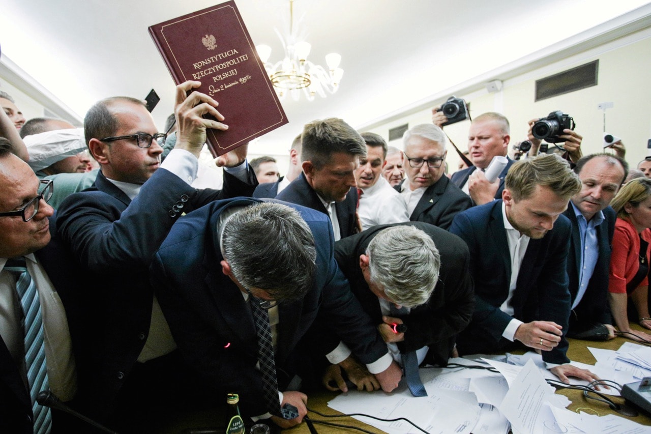 Michal Szczerba of Civic Platform party holds up a copy of the Constitution as members of parliament scuffle during a vote on a bill calling for an overhaul of the Supreme Court, Warsaw, Poland, 20 July 2017, Agencja Gazeta/Adam Stepien/via REUTERS