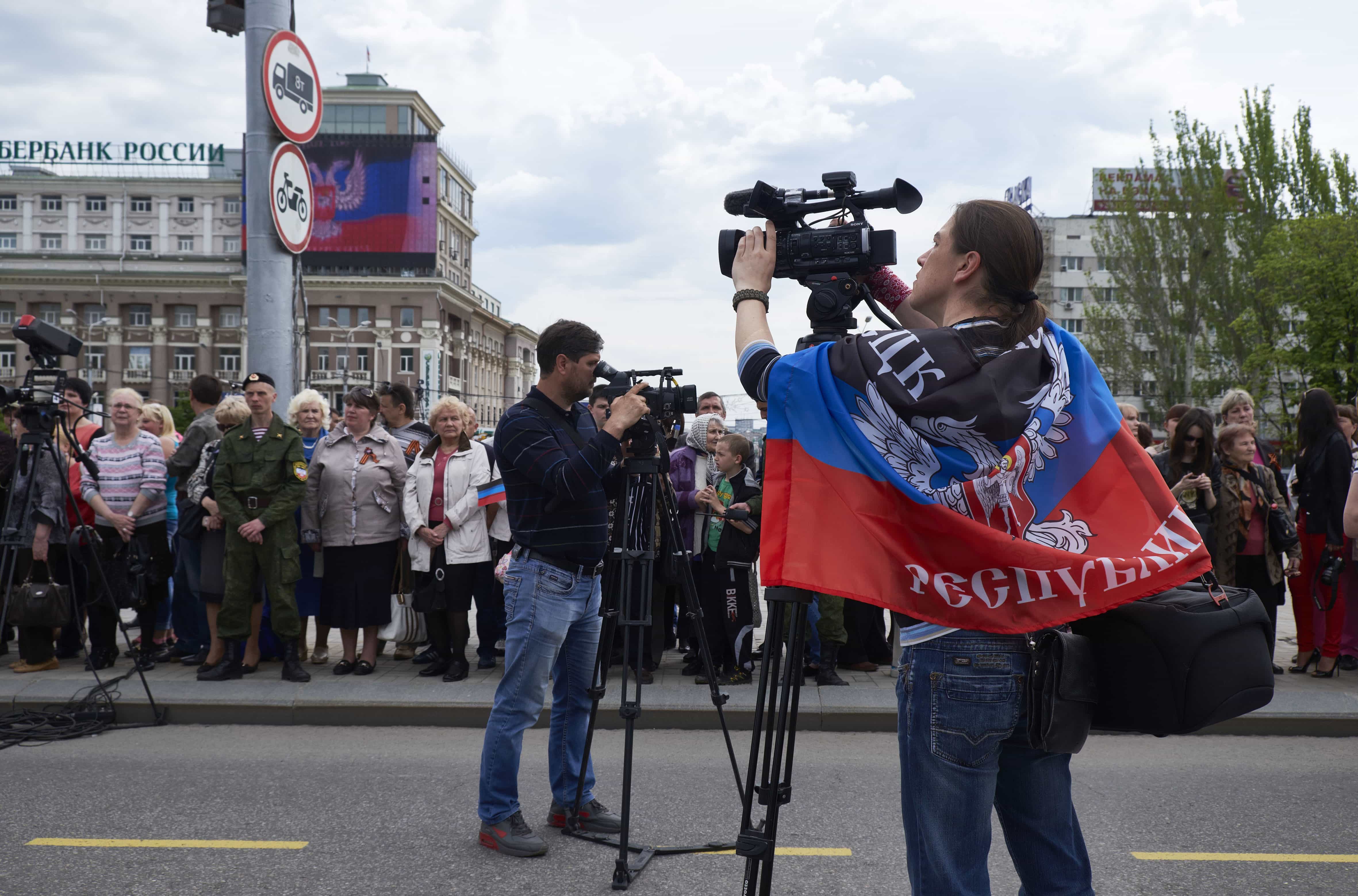 A camera operator wears a DPR flag as residents of the Donetsk region celebrate the first anniversary of the so called, pro-Russia self-proclaimed state, Donetsk People's Republic, Donetsk, Ukraine, 11 May 2015, Pierre Crom/Getty Images