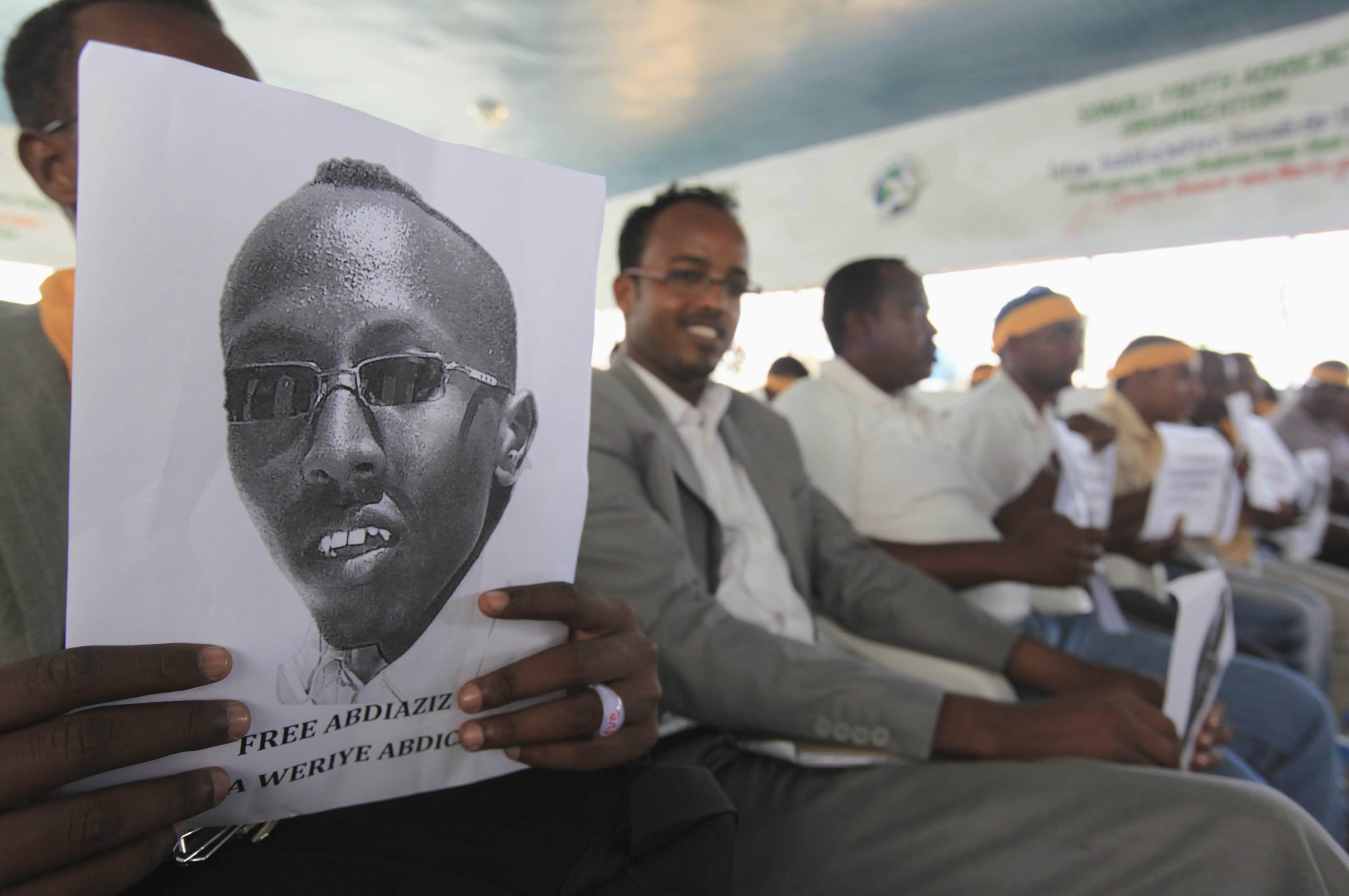 A Somali journalist holds a poster bearing the image of detained reporter Abdiaziz Abdinur Ibrahim in Mogadishu, 27 January 2013., REUTERS/Feisal Omar