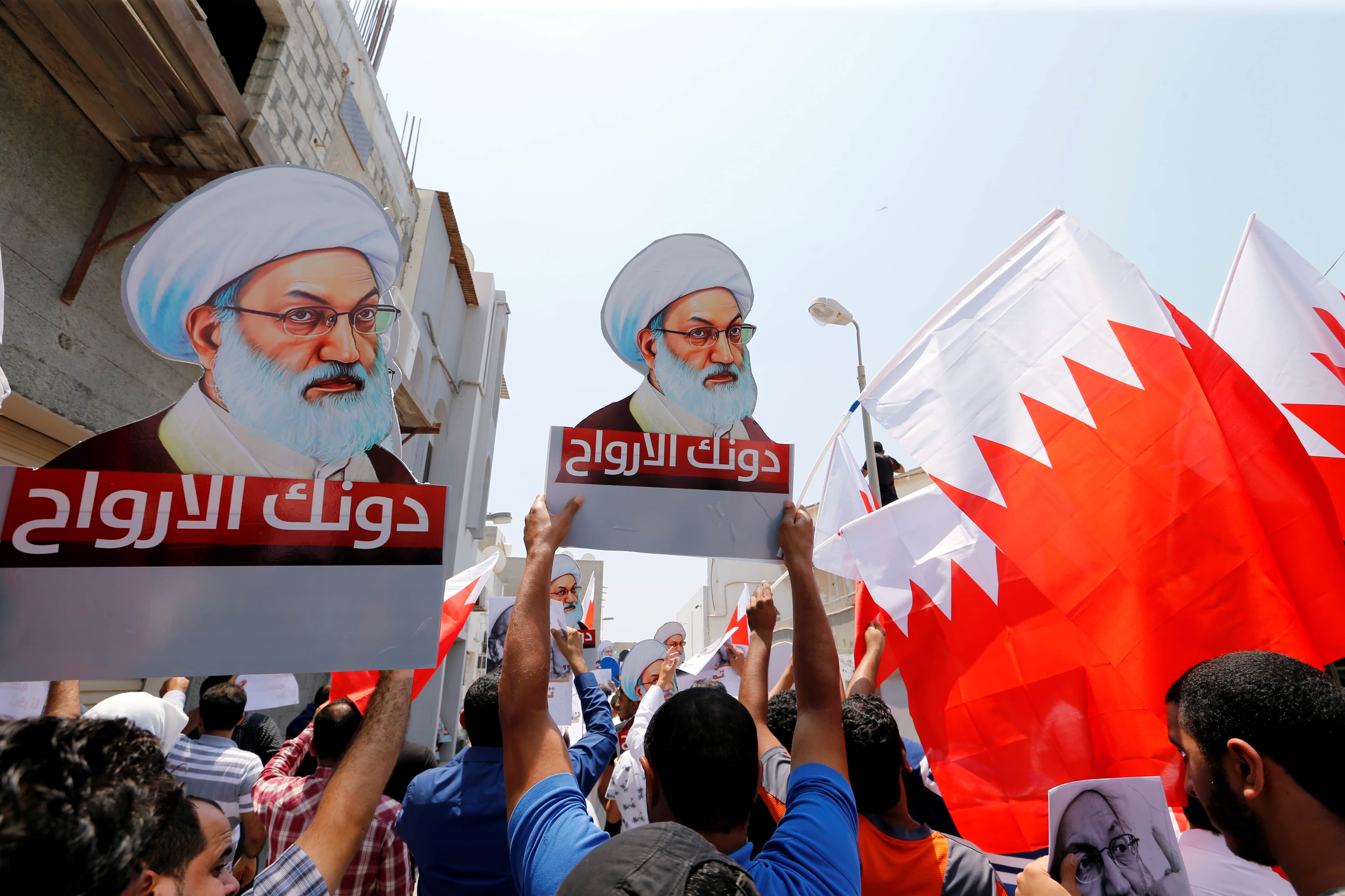 Protesters holding Bahraini flags and placards with images of Bahrain's leading Shi'ite cleric Isa Qassim, shout religious slogans during an anti-government protest after Friday prayers in the village of Diraz, west of Manama, Bahrain, August 12, 2016. The placards read, "We sacrifice our souls for you". , REUTERS/Hamad I Mohammed