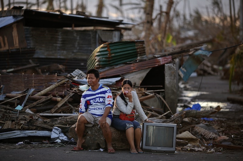 Survivors of Typhoon Haiyan wait for transportation out of a devastated part of Tanauan, 16 November 2013 , REUTERS/Damir Sagolj
