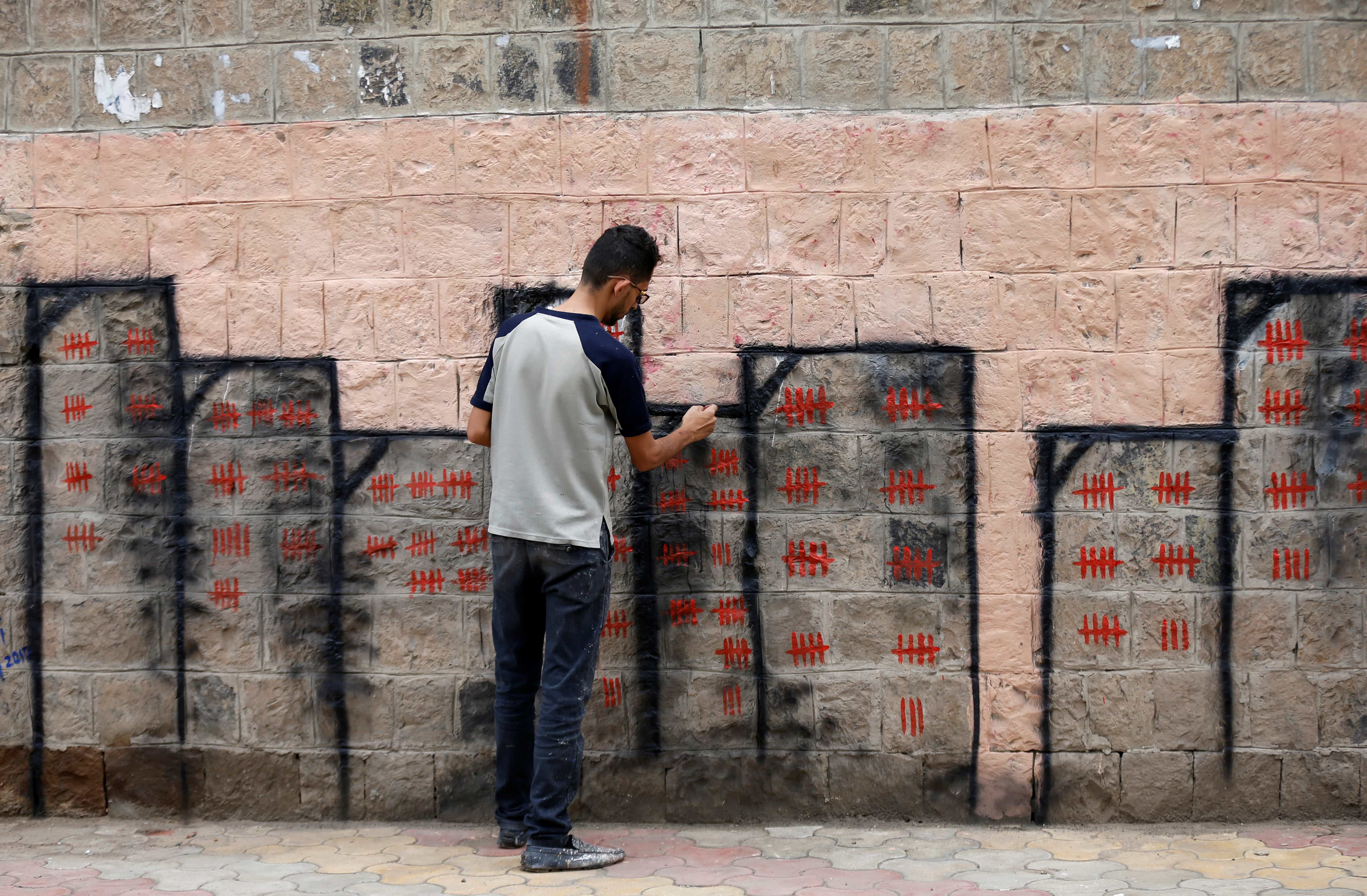 Artist and activist Thiyazen al-Alawi paints a mural on a wall of a hospital as part of a cholera awareness campaign in Sanaa, Yemen, May 23, 2017, REUTERS/Khaled Abdullah