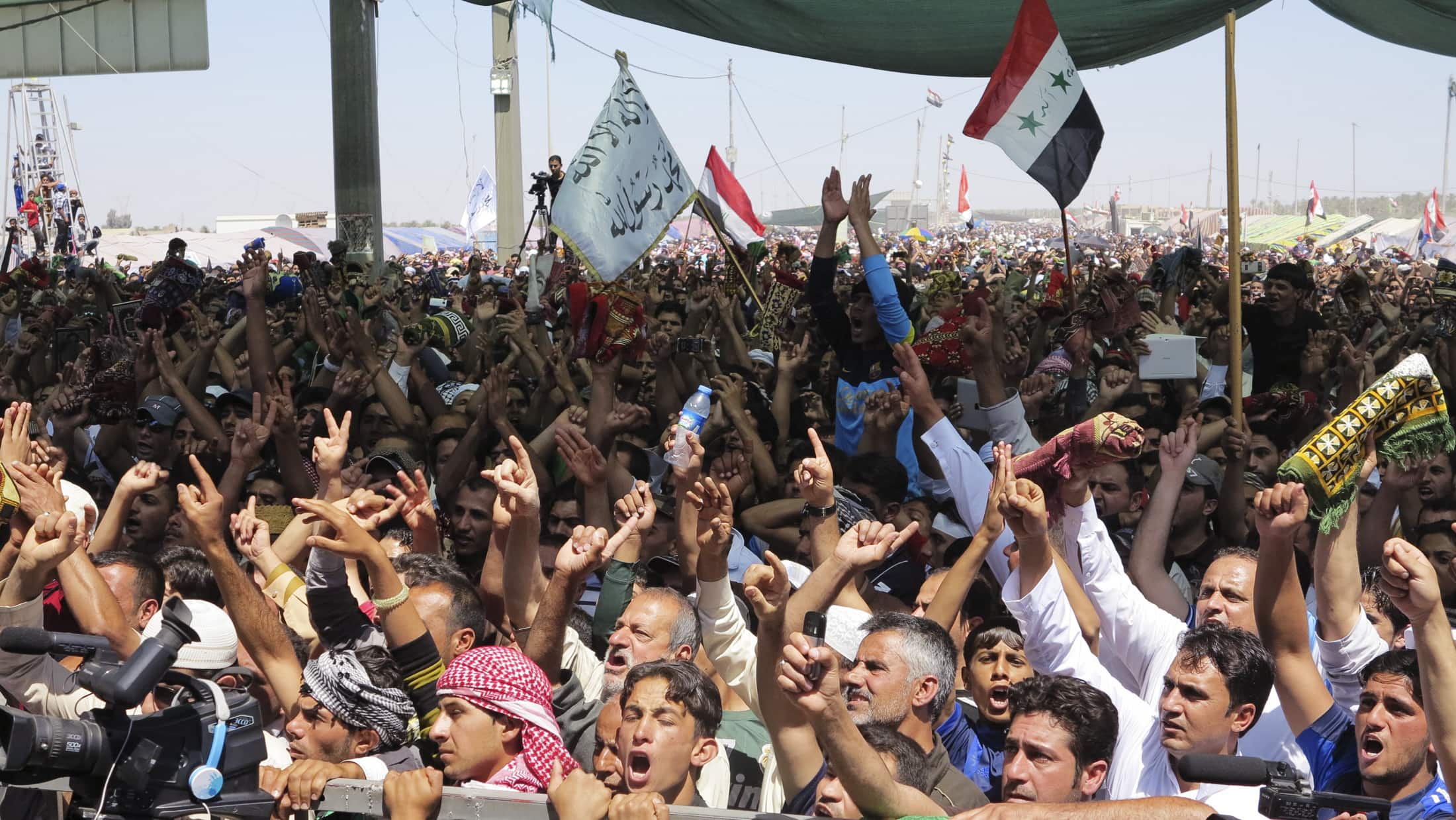 Sunni Muslims chant "Allahu Akbar", meaning "God is great", as they wave old Iraqi flags during an anti-government demonstration west of Baghdad on 26 April 2013, REUTERS/Ali al-Mashhadani